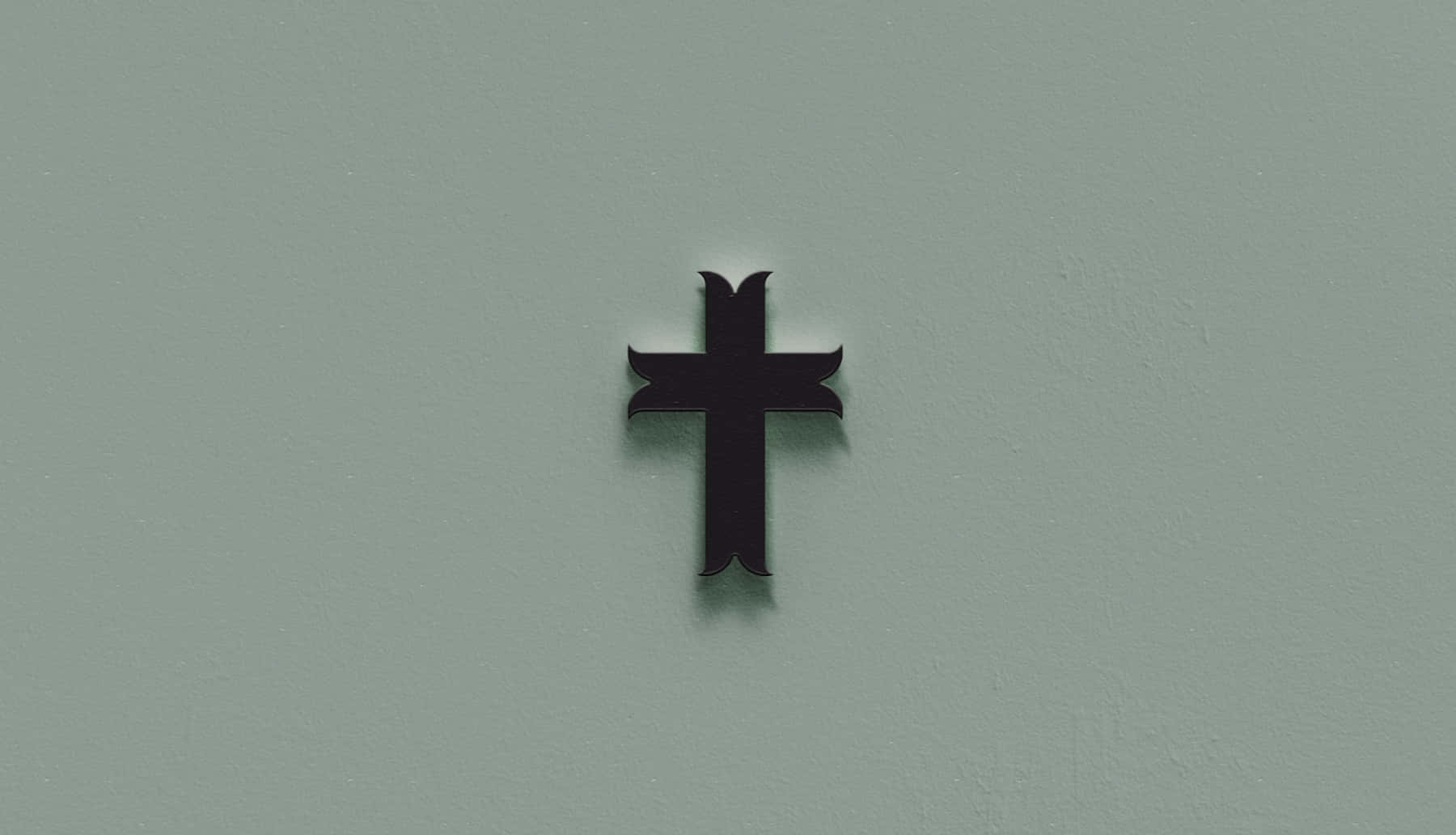 A Black Cross Is Placed On A Wall Background