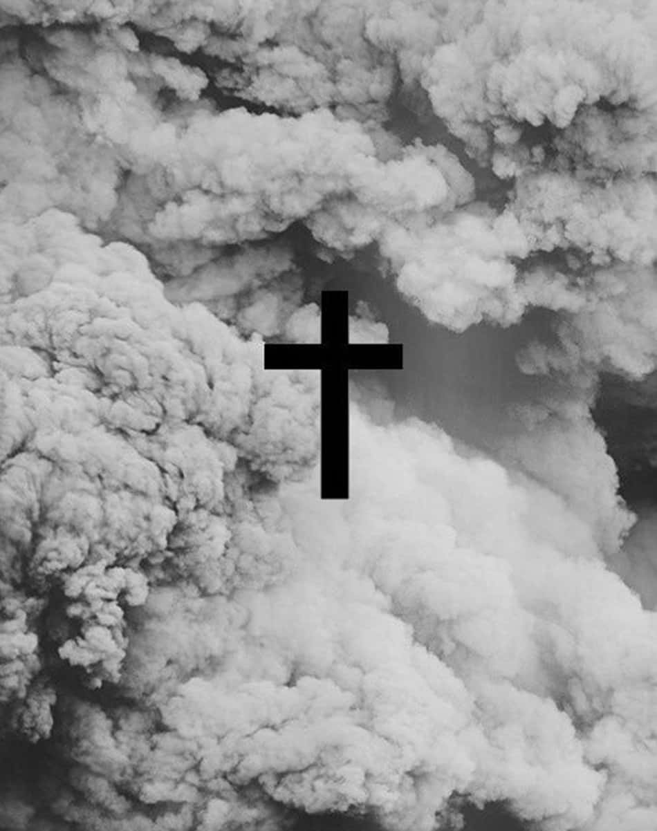 A Black Cross Lone Against A White Sky Background