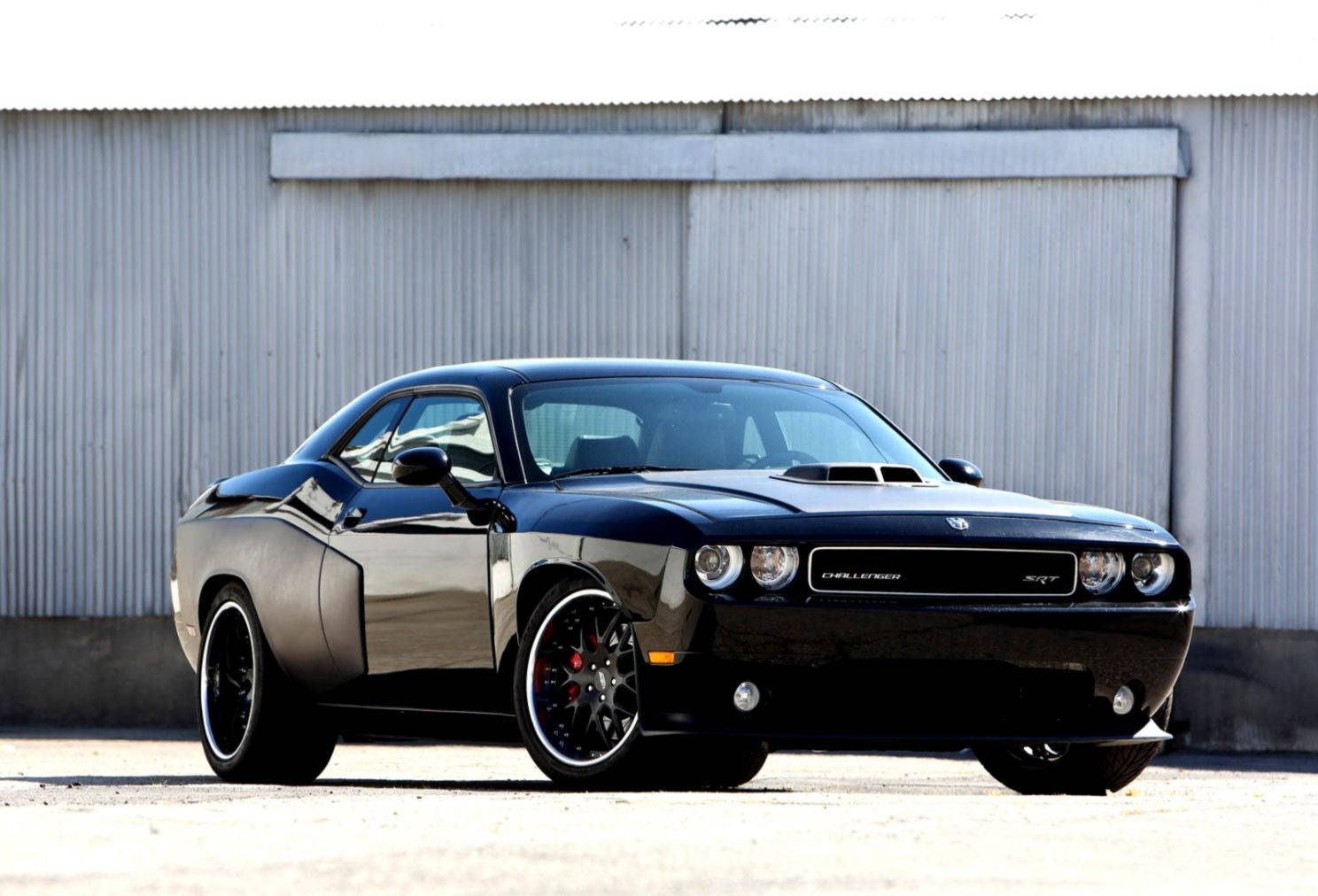 A Black Dodge Challenger Parked In Front Of A Building Background