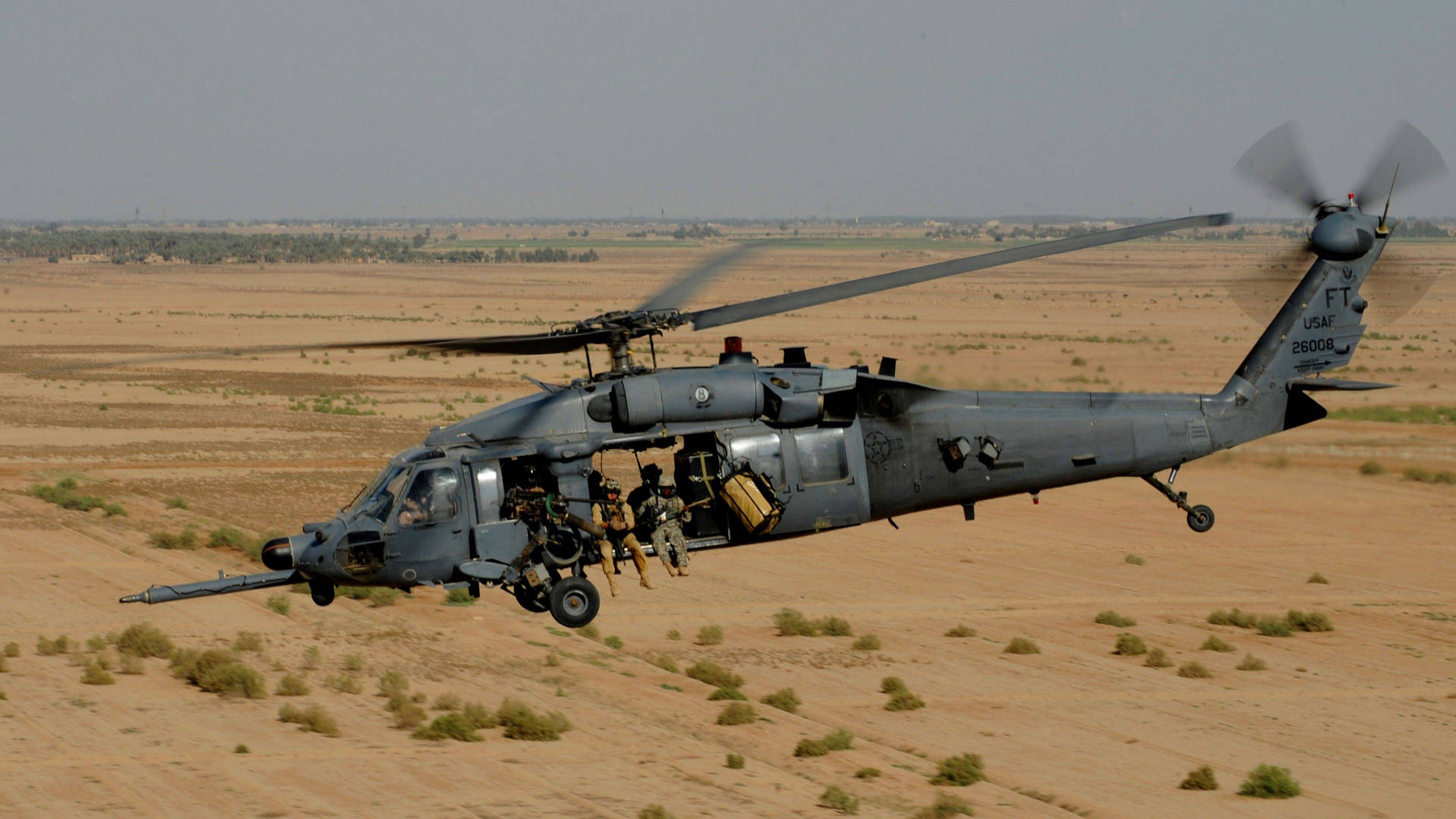 A Black Hawk Helicopter Hovering In The Sky Background