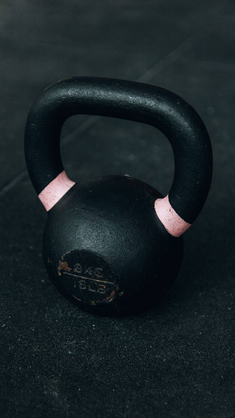 A Black Kettlebell On A Black Surface Background