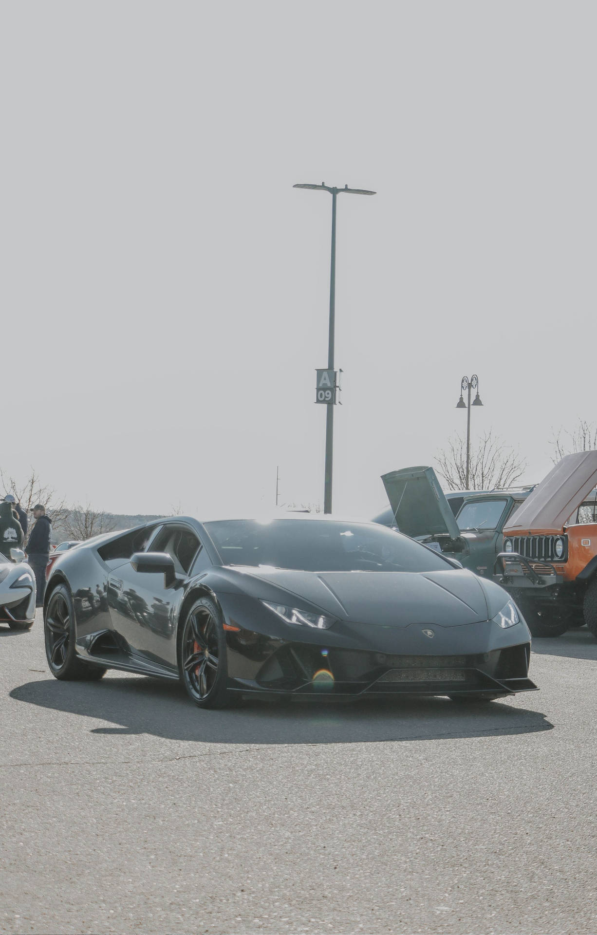 A Black Lamborghini Gt4 Parked In A Parking Lot Background