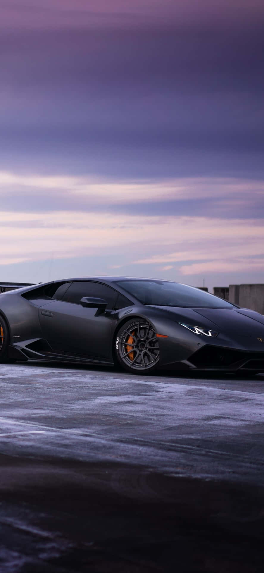 A Black Lamborghini Parked On A Snowy Road Background
