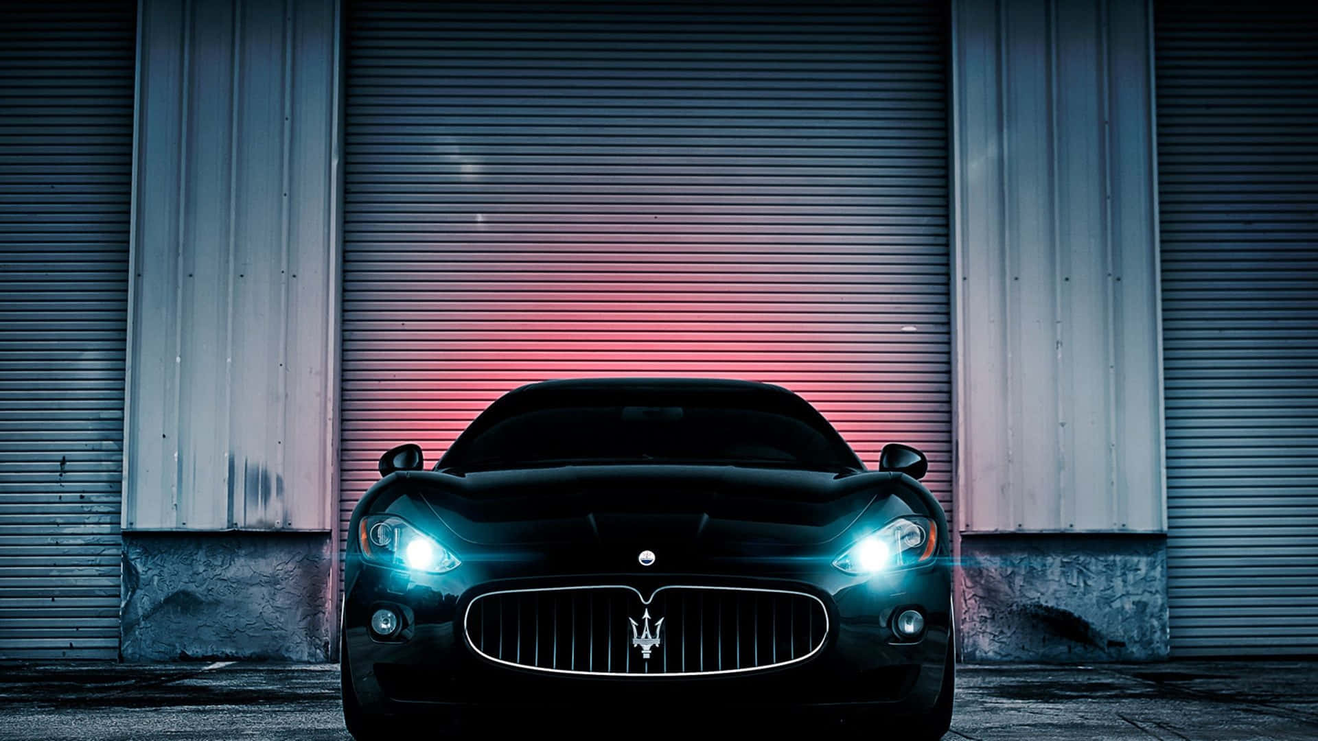 A Black Maserati Parked In Front Of A Garage