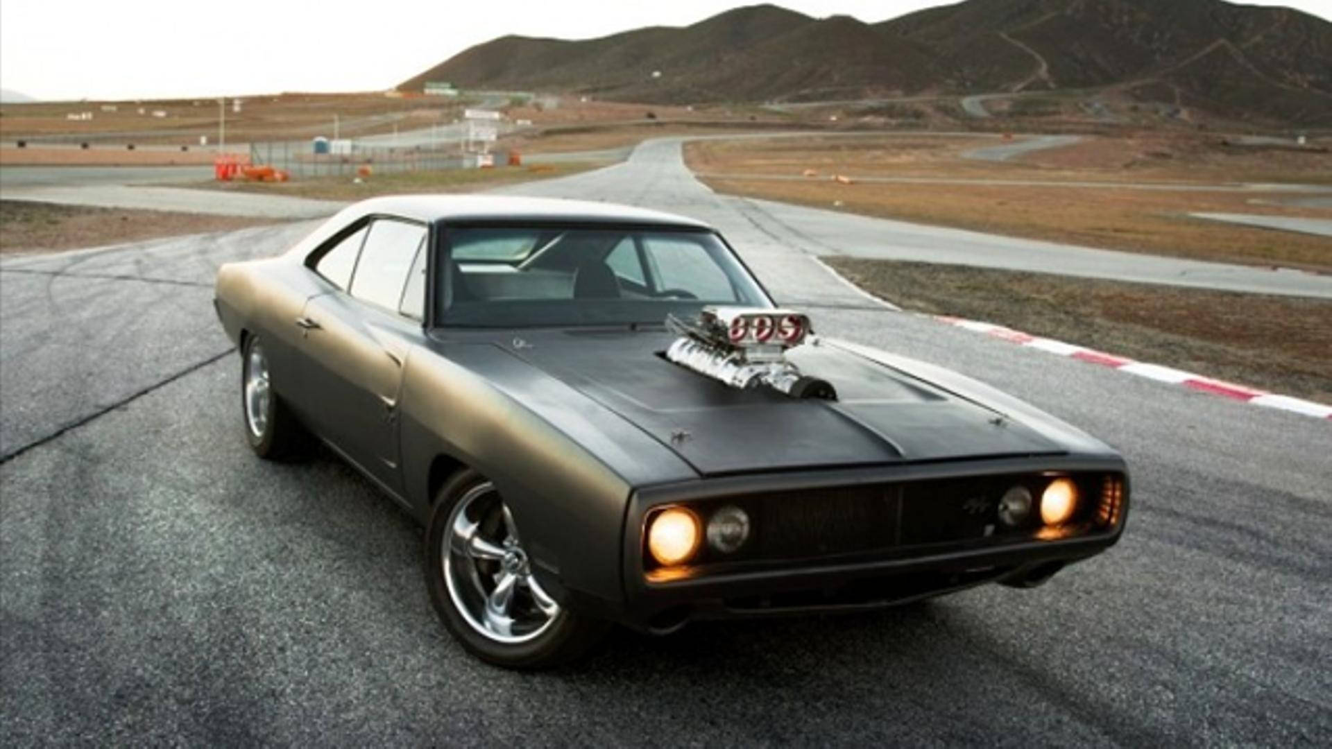 A Black Muscle Car Is Driving Down A Road Background