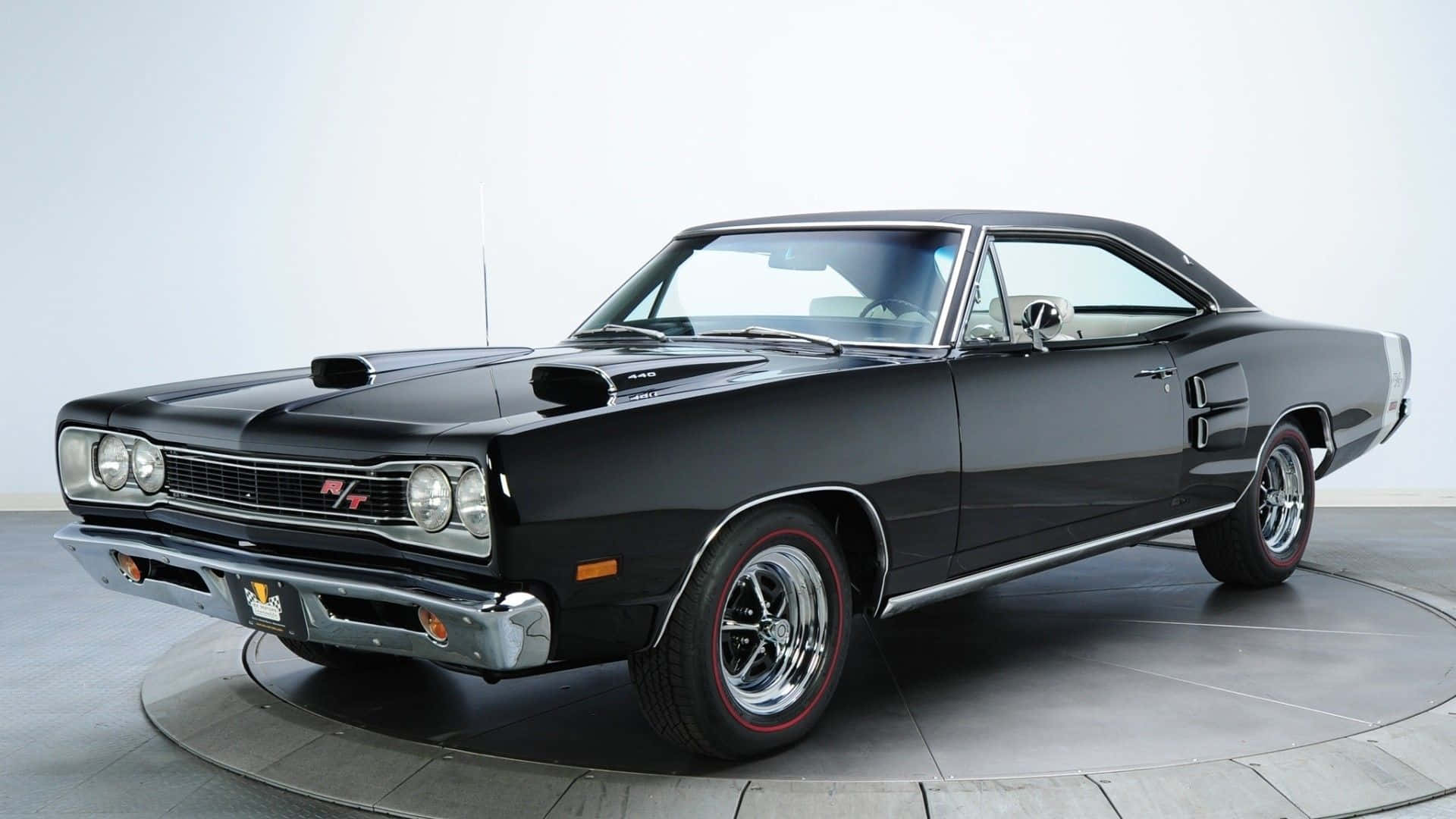 A Black Muscle Car Is Parked On A Circular Platform