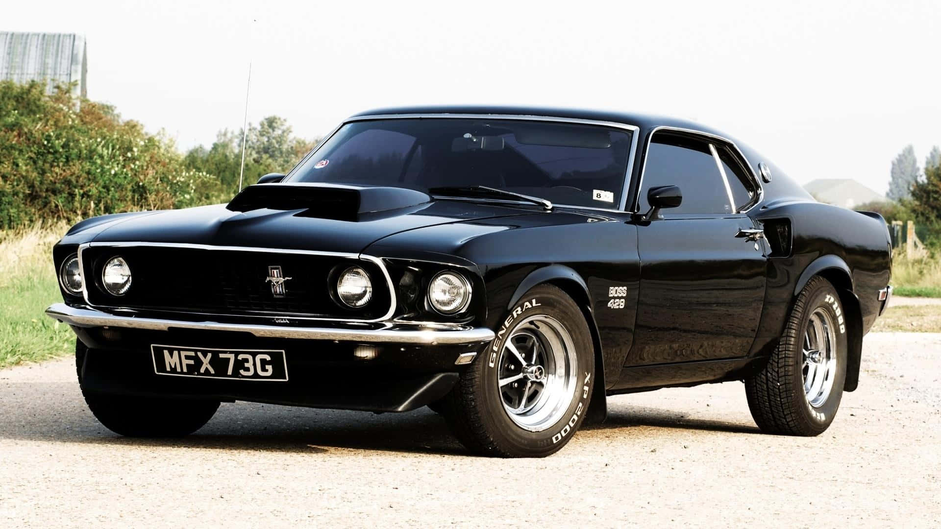 A Black Mustang Parked On A Dirt Road Background