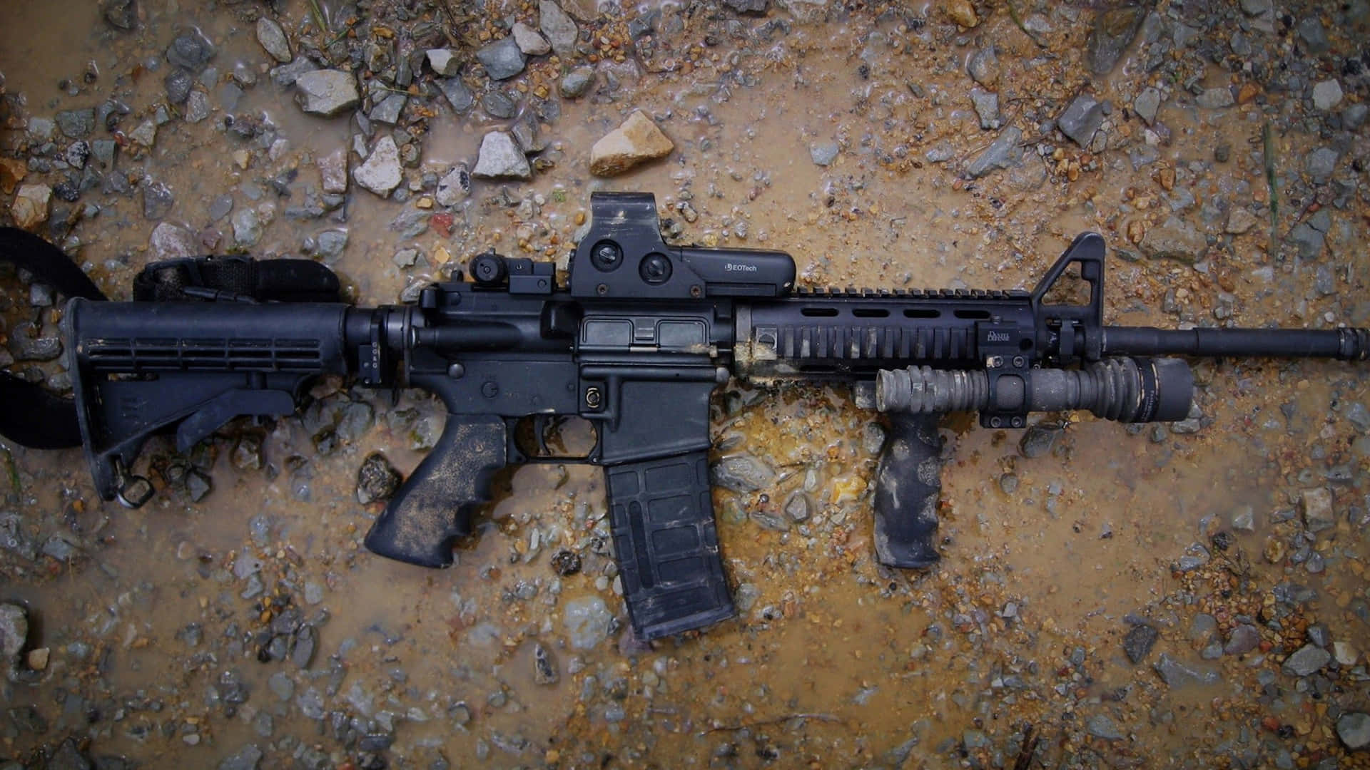 A Black Rifle Is Laying On The Ground Background