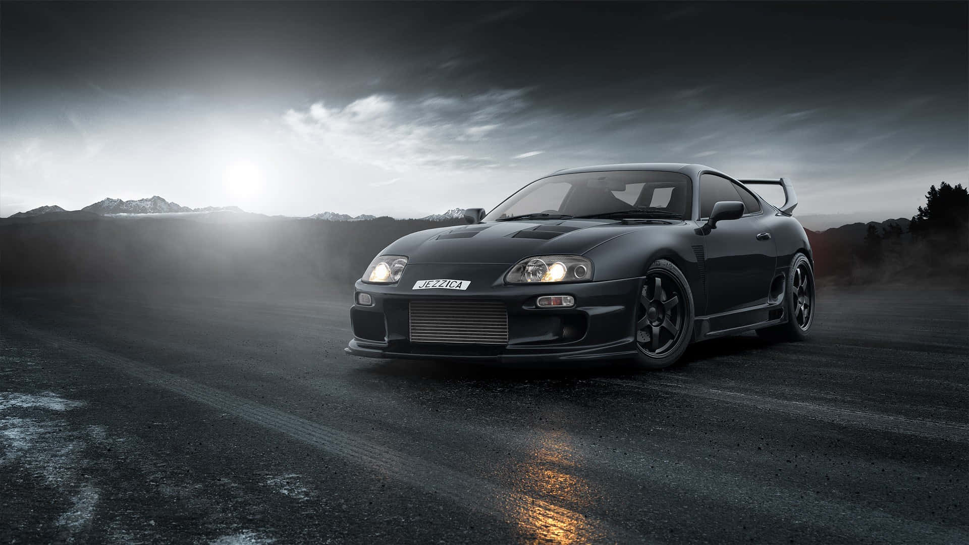 A Black Sports Car Driving On A Road Background