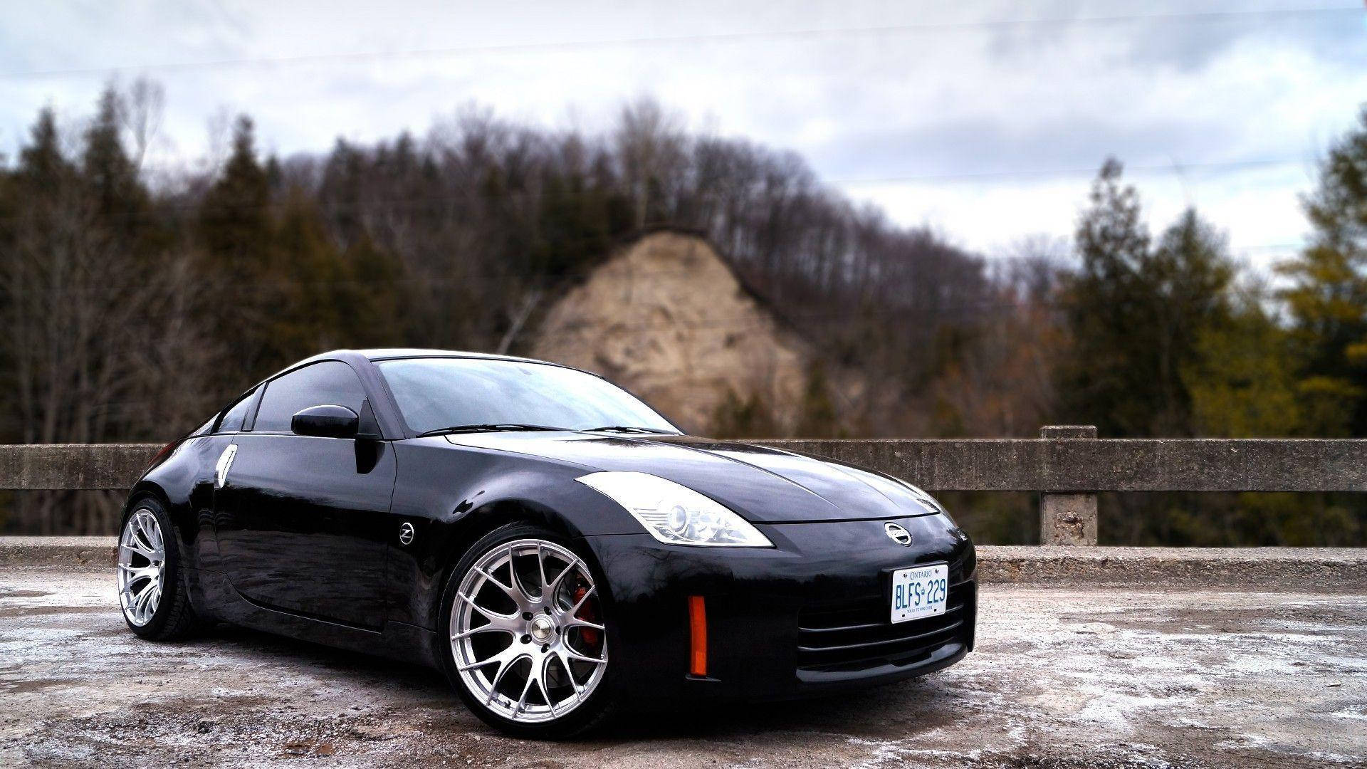 A Black Sports Car Is Parked On A Bridge Background