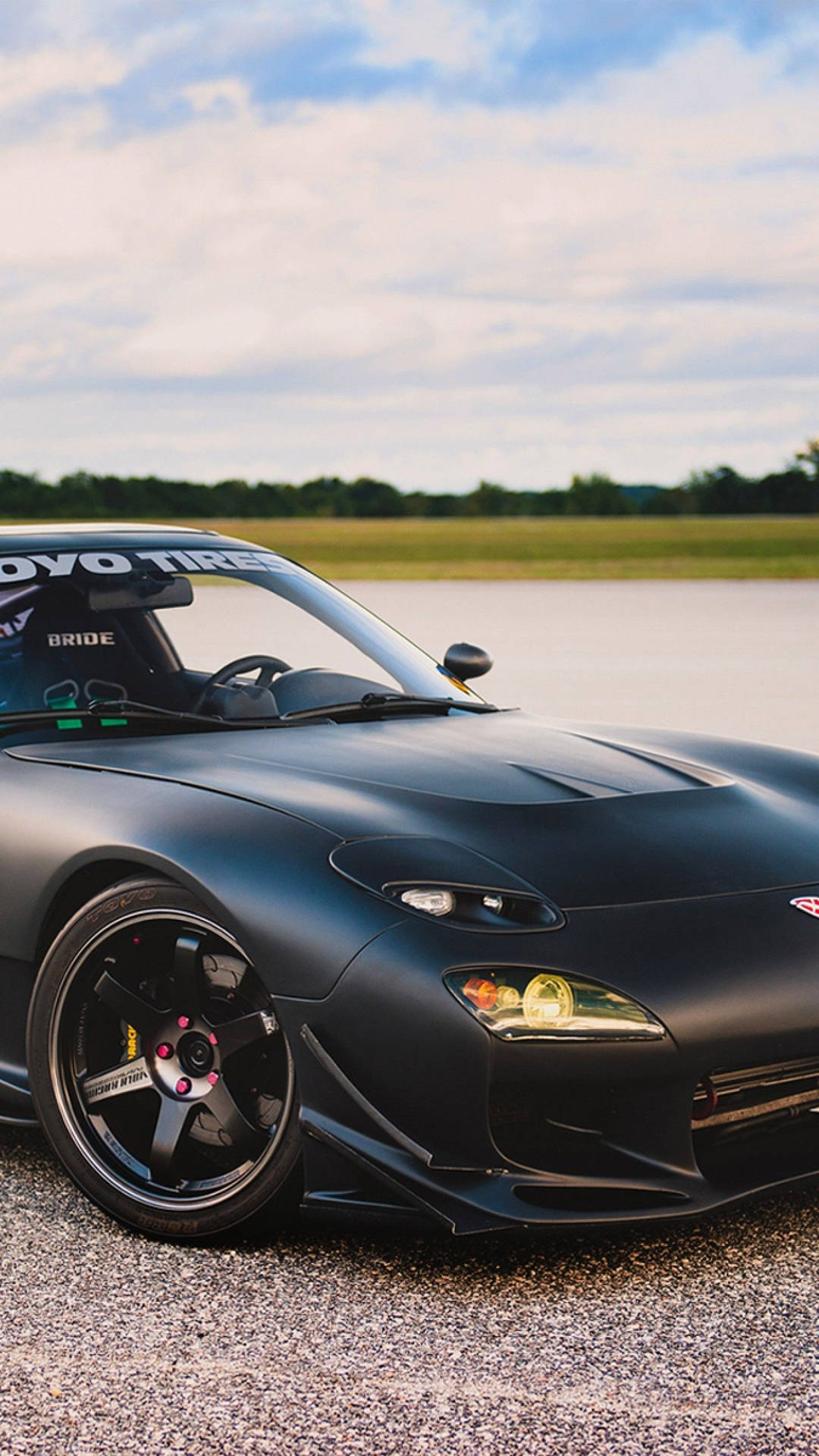 A Black Sports Car Is Parked On A Road Background