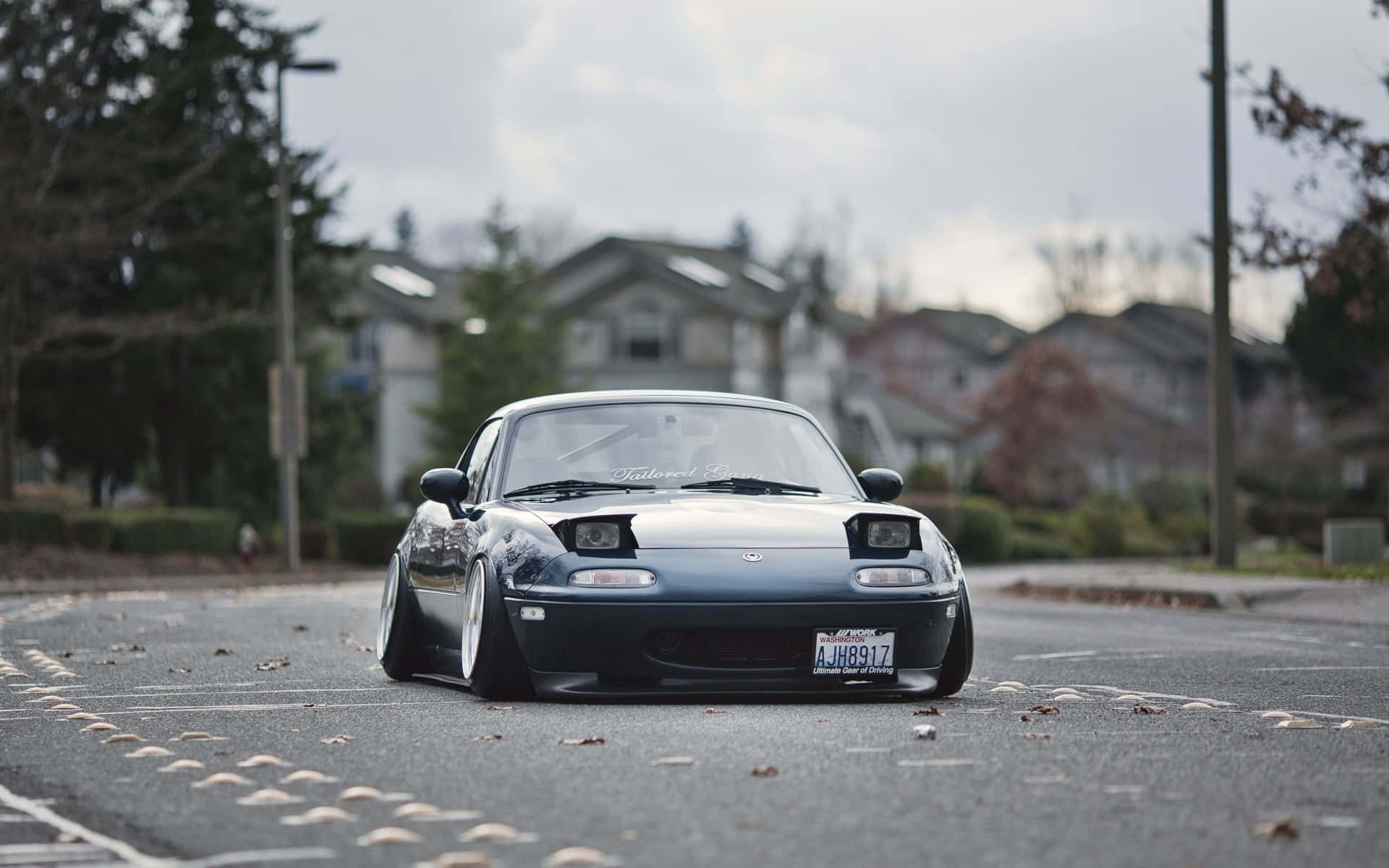 A Black Sports Car Is Parked On A Street Background