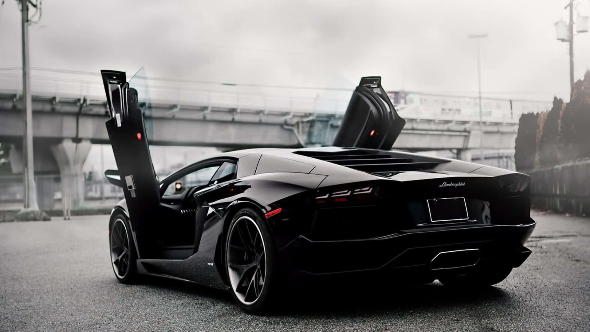 A Black Sports Car Is Parked On A Street Background