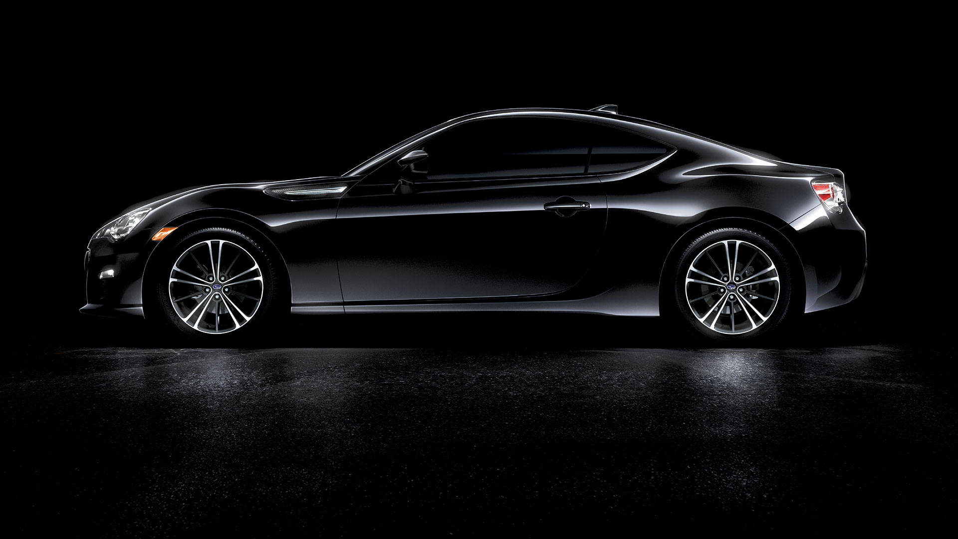 A Black Sports Car Is Shown In A Dark Room Background