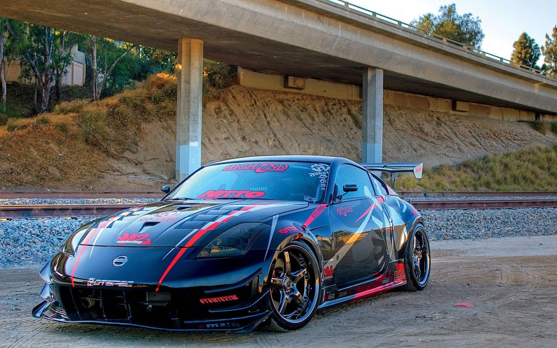 A Black Sports Car Parked Under A Bridge Background