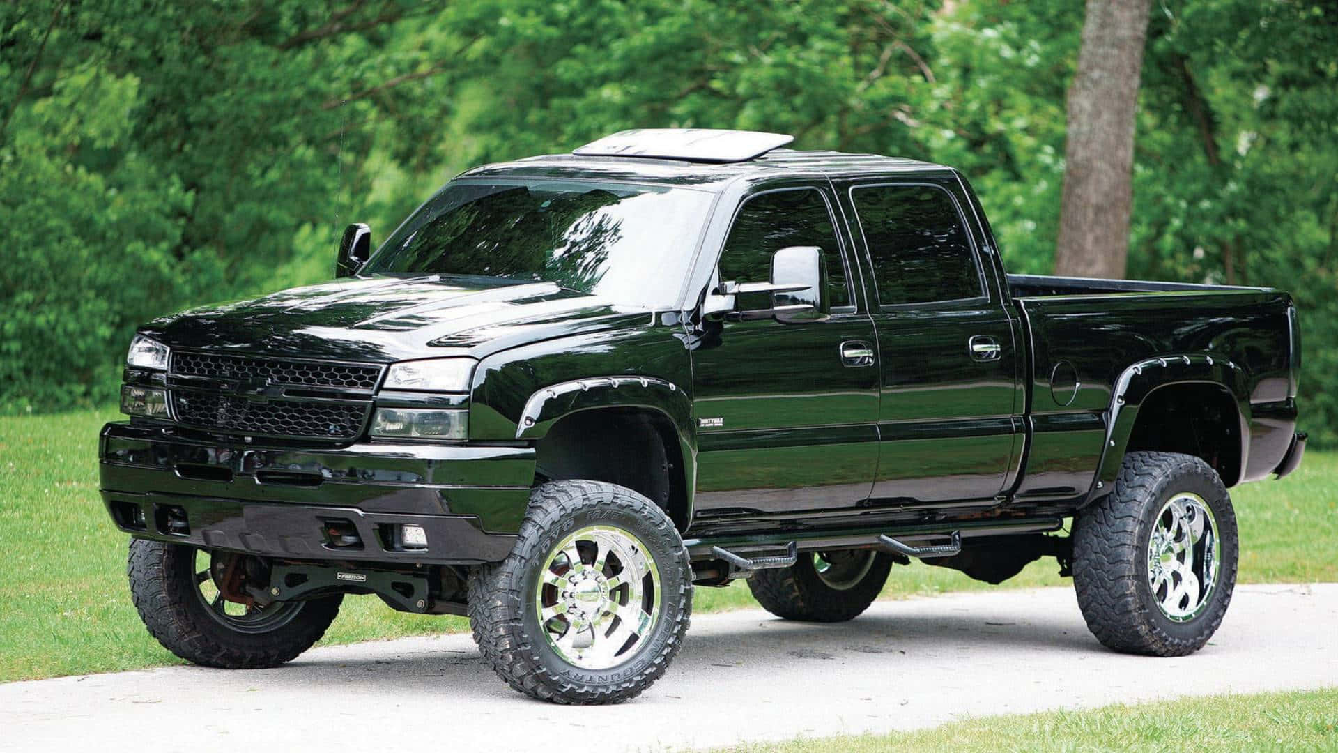 A Black Truck Is Parked On A Road