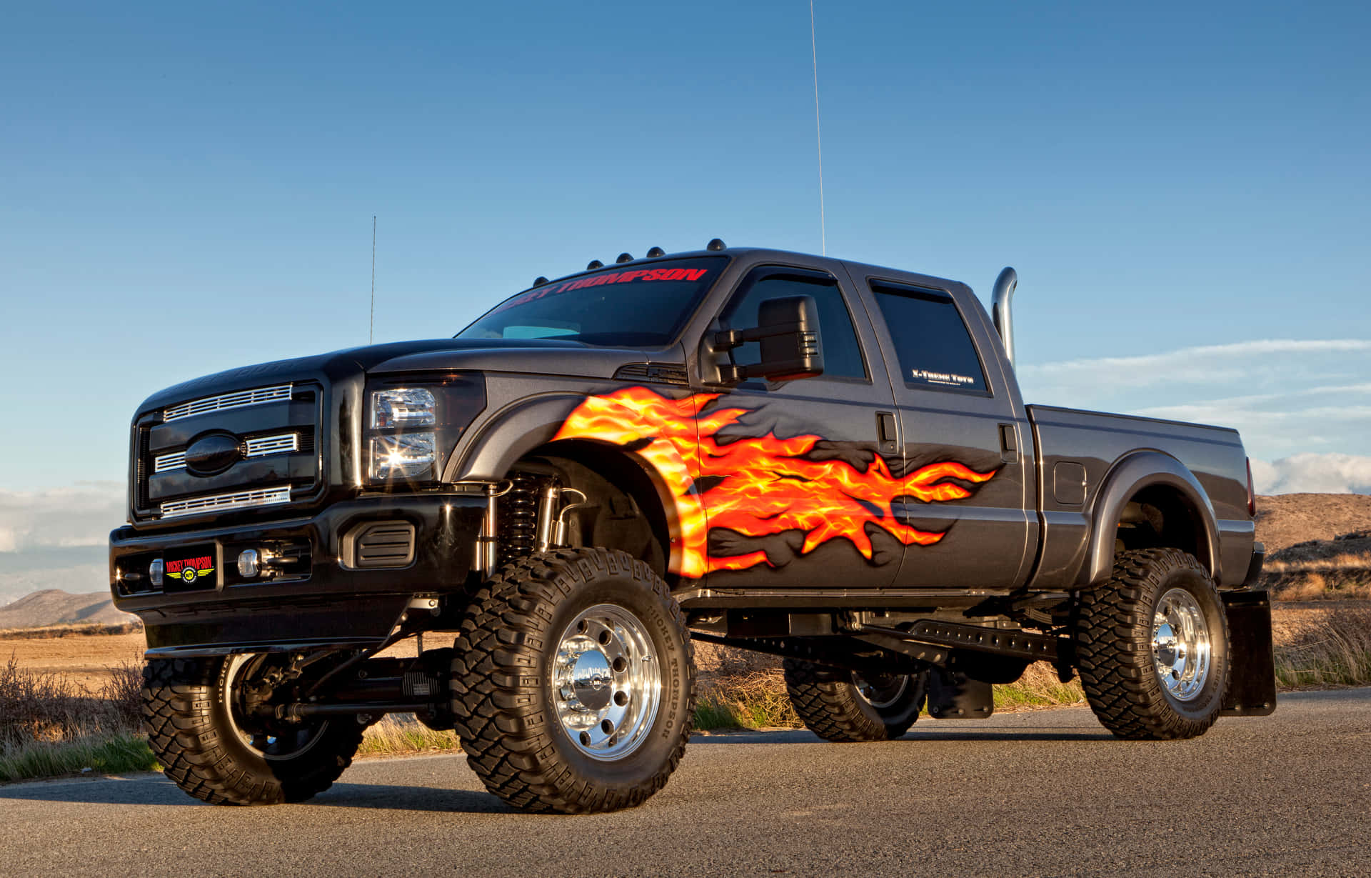 A Black Truck With Flames On It Background
