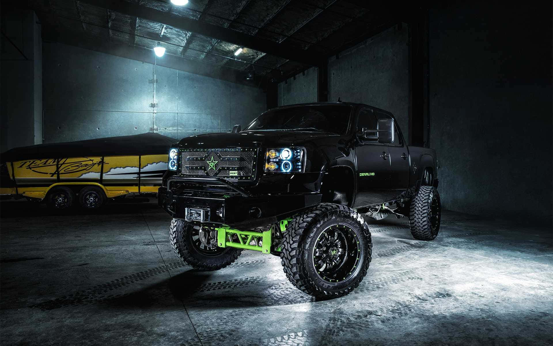 A Black Truck With Green Lights In A Garage Background