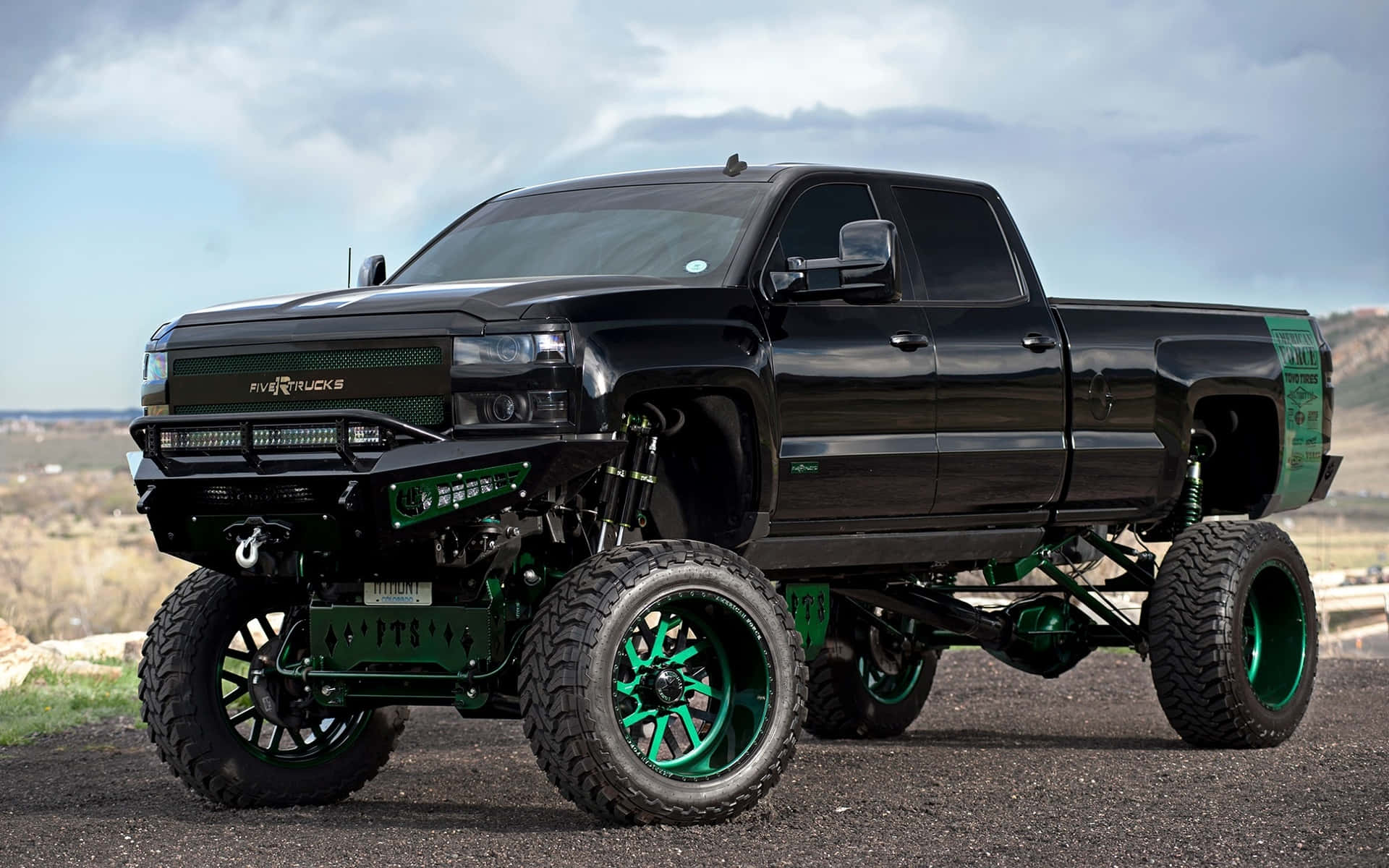 A Black Truck With Green Wheels On It Background