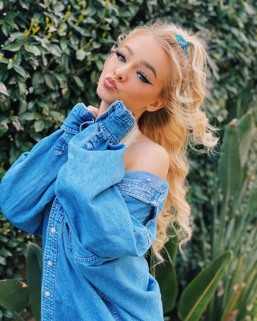 A Blonde Woman In A Blue Denim Shirt Posing For A Photo Background