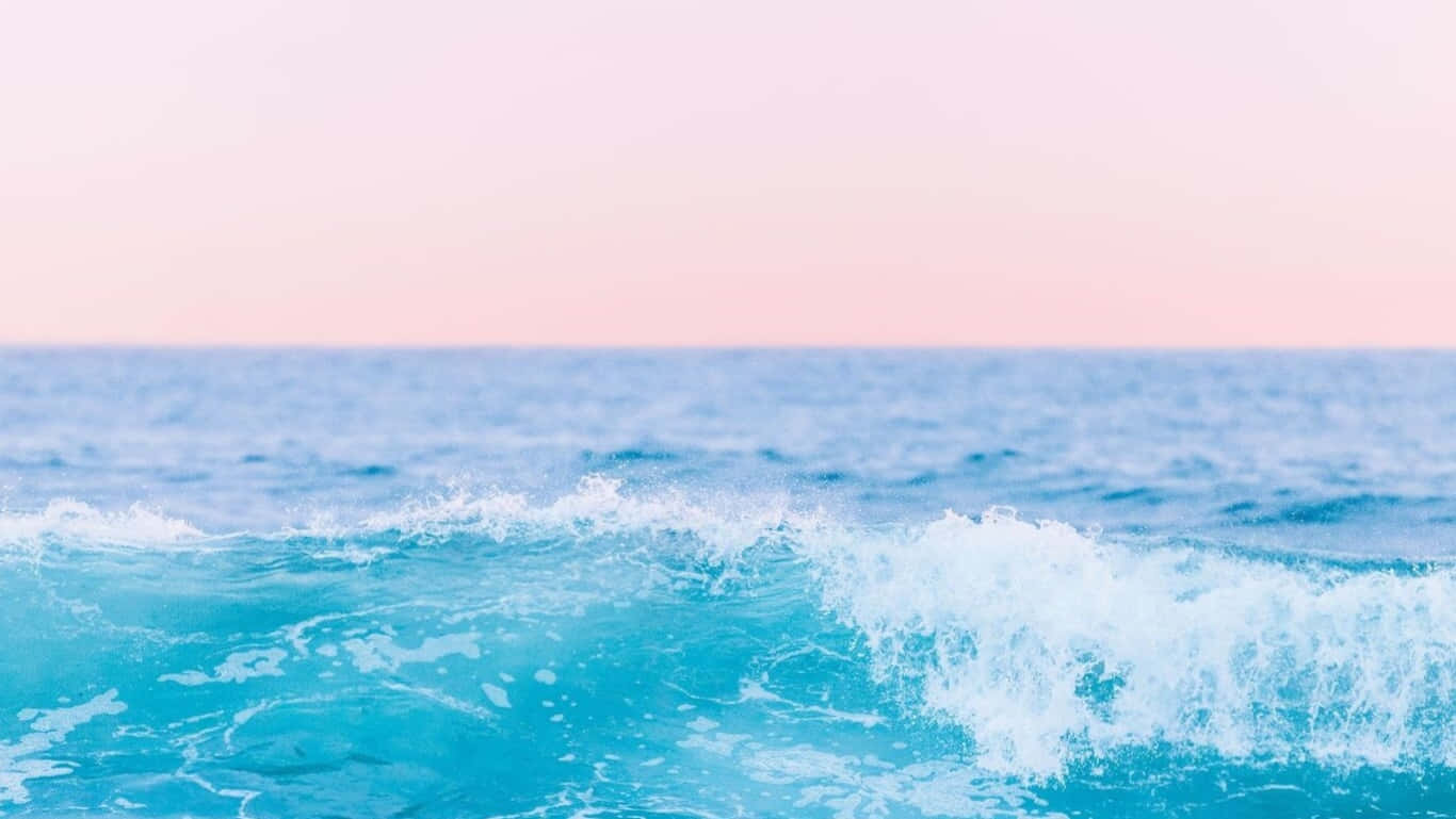 A Blue And Pink Ocean With Waves Crashing Background