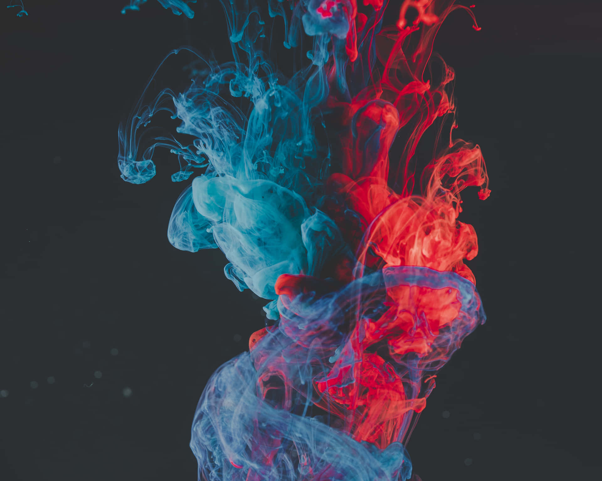 A Blue And Red Liquid Is Floating In The Air Background