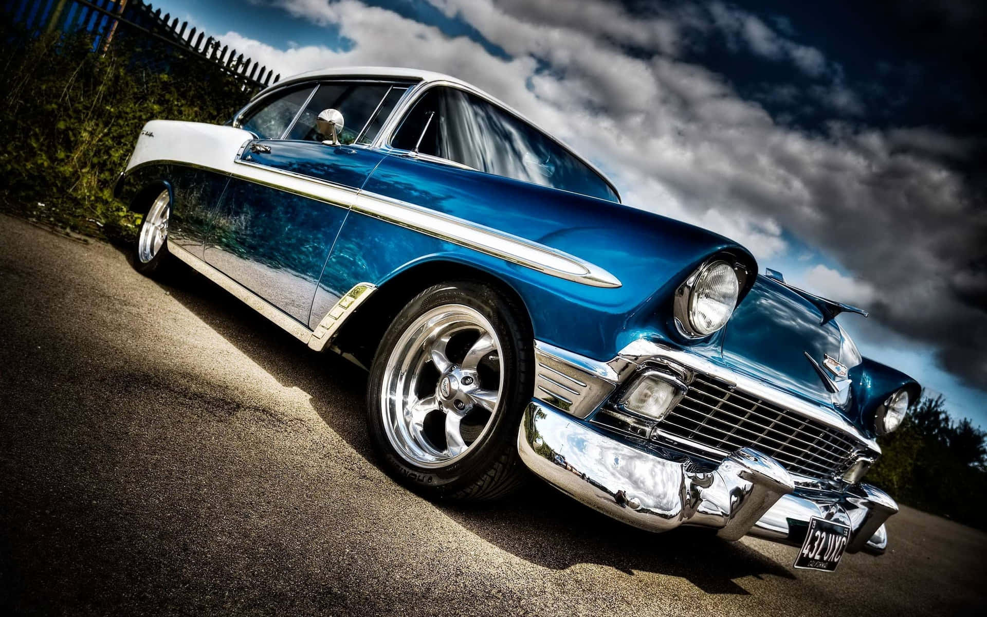 A Blue And White Classic Car Parked In The Parking Lot Background