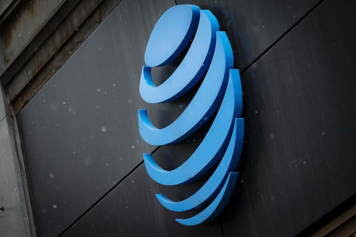 A Blue And White Logo On The Side Of A Building Background