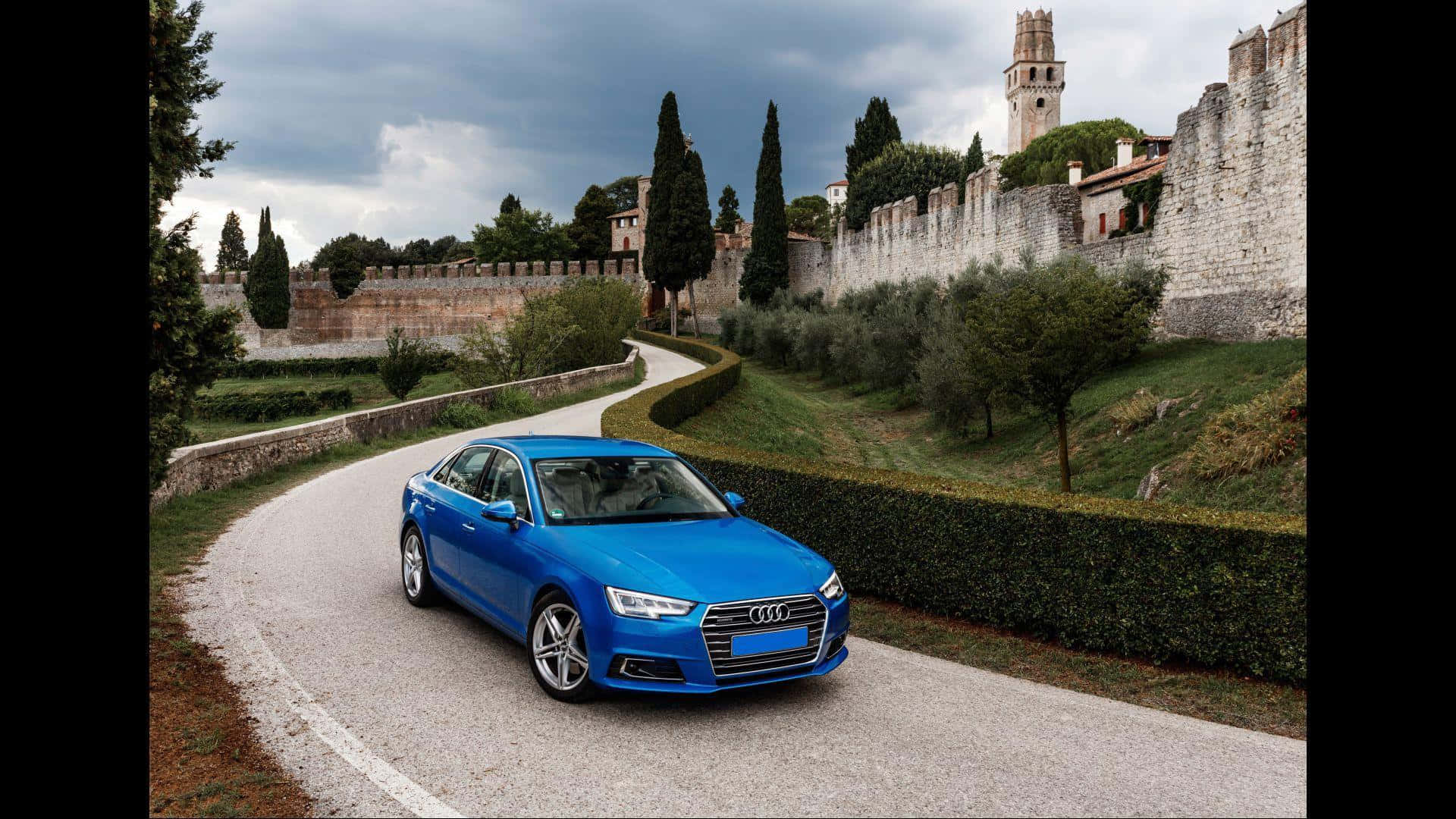 A Blue Audi A4 Driving Down A Road