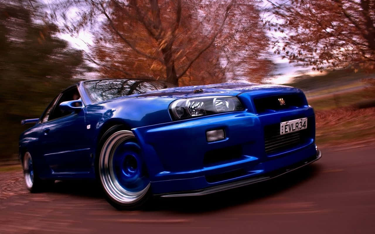 A Blue Car Driving Down A Road Background