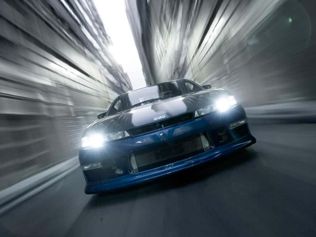 A Blue Car Driving Down A Street In A Dark Tunnel