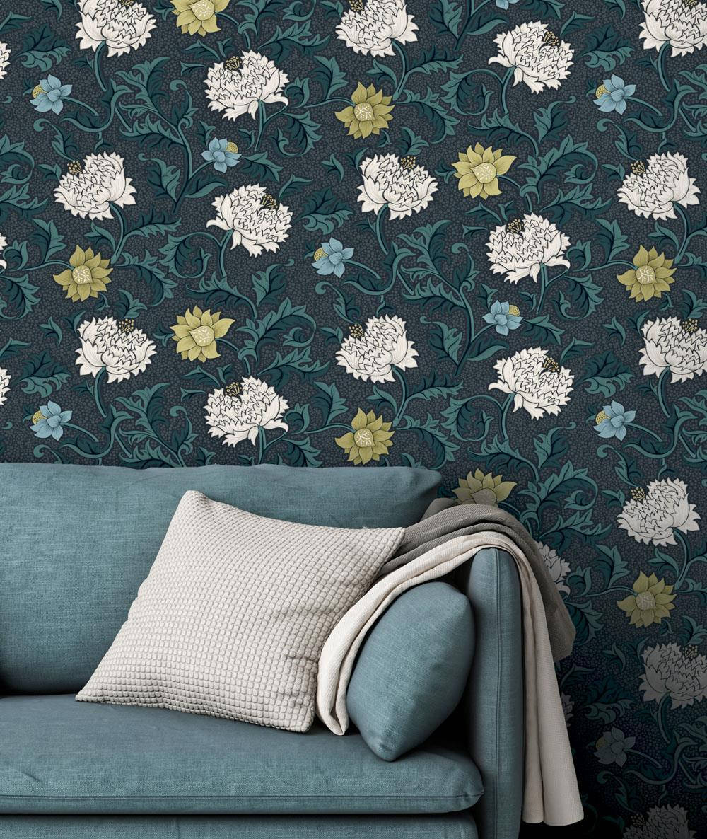 A Blue Couch With Floral Wallpaper In Front Of It Background