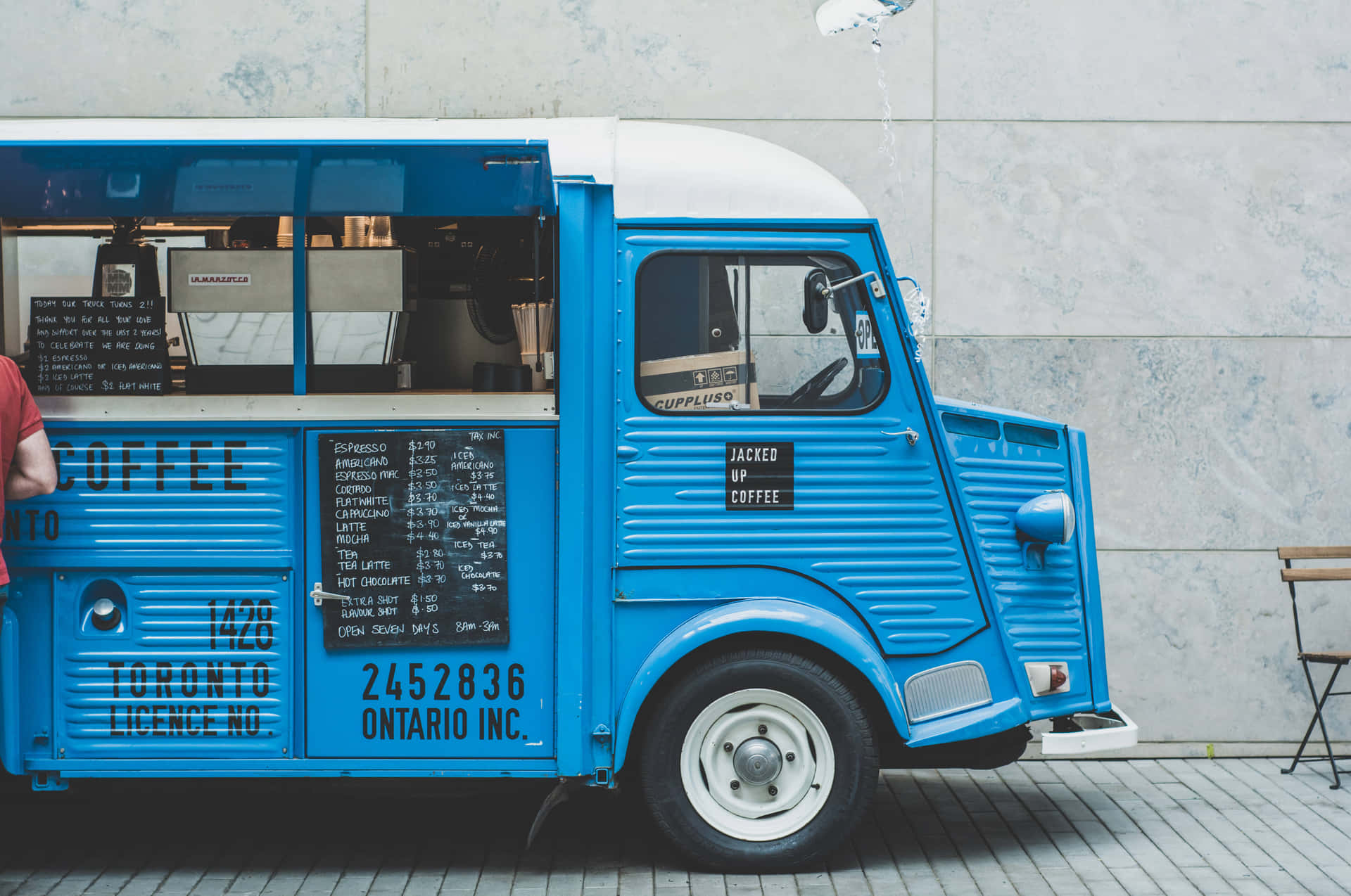 A Blue Food Truck With A Man Standing Next To It Background