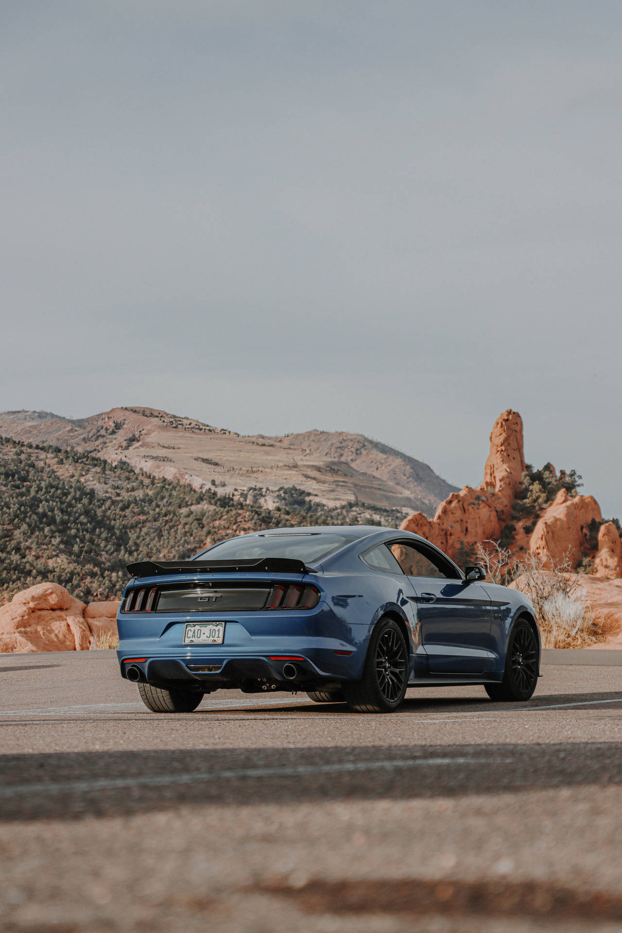 A Blue Ford Mustang Gt Parked In The Desert Background