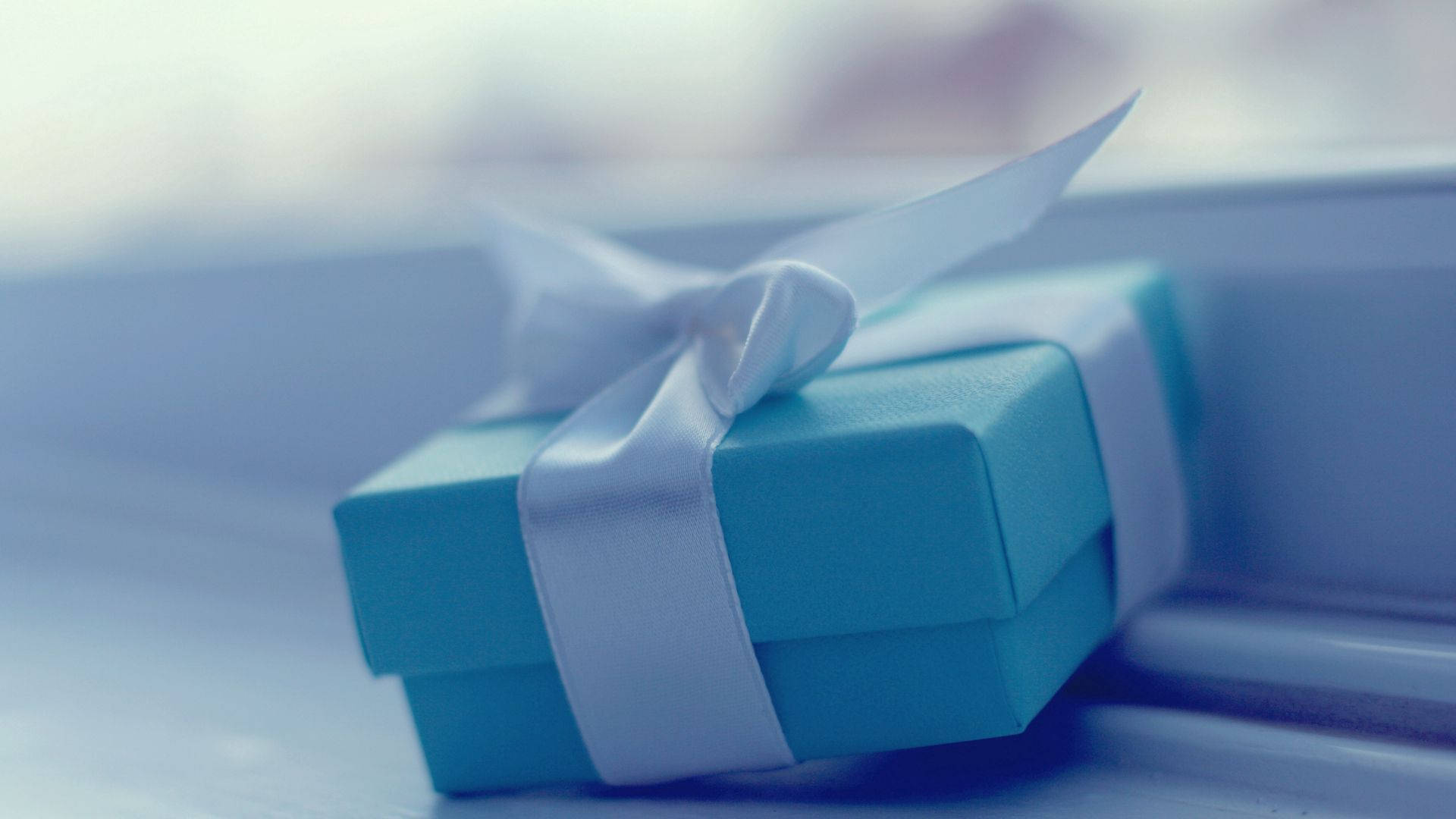 A Blue Gift Box Sitting On A Window Sill Background
