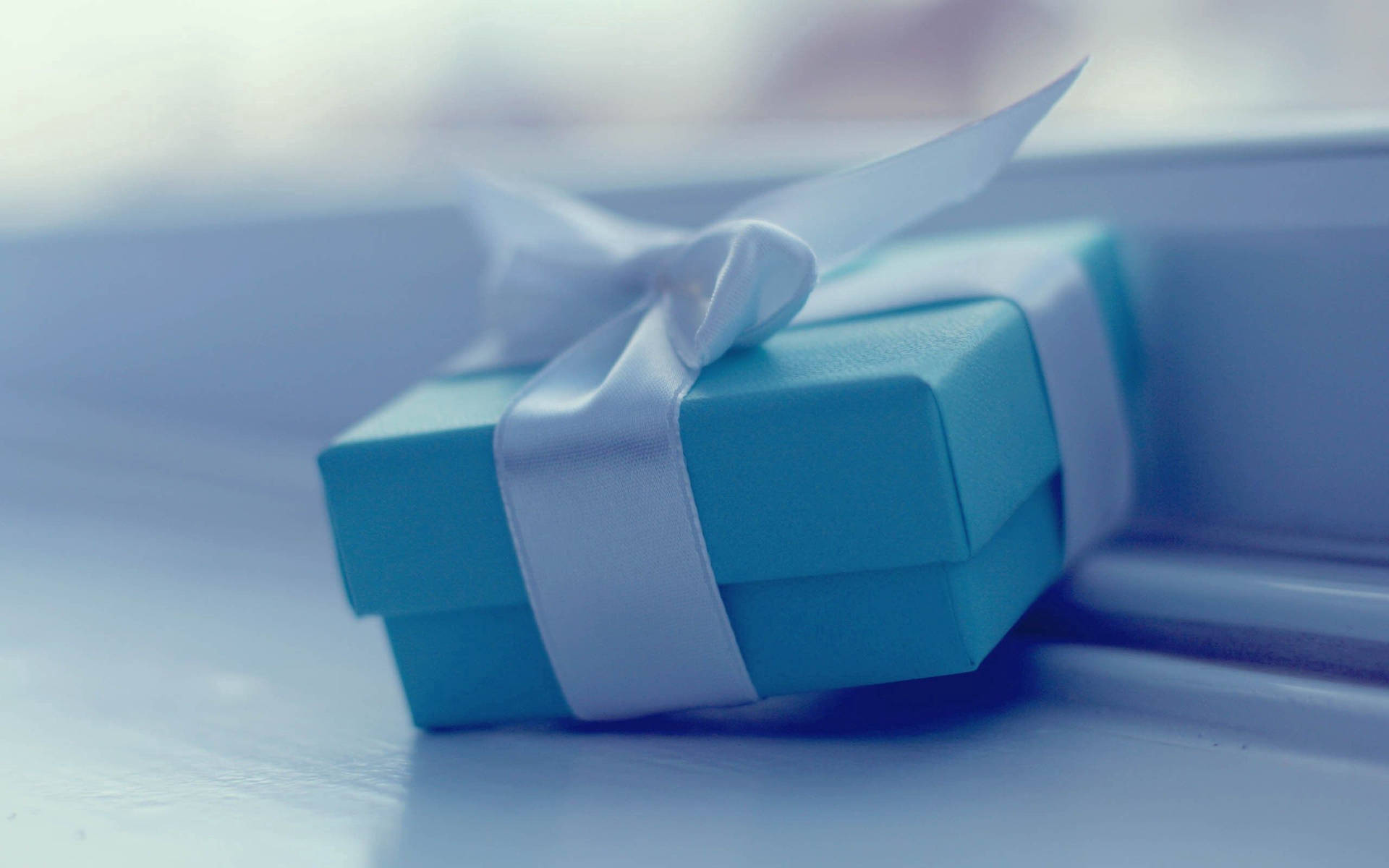 A Blue Gift Box With A Bow On It Background