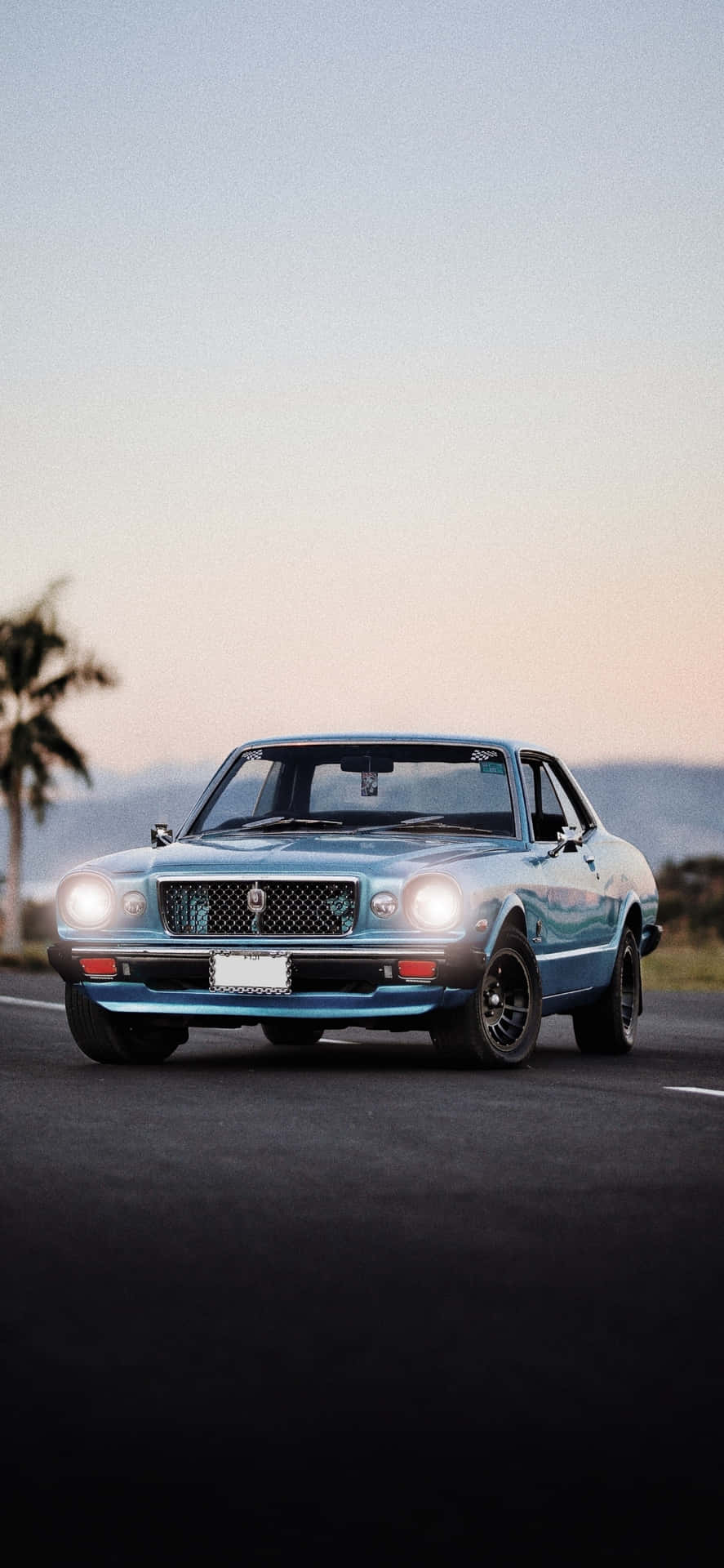 A Blue Mustang Is Driving Down The Road