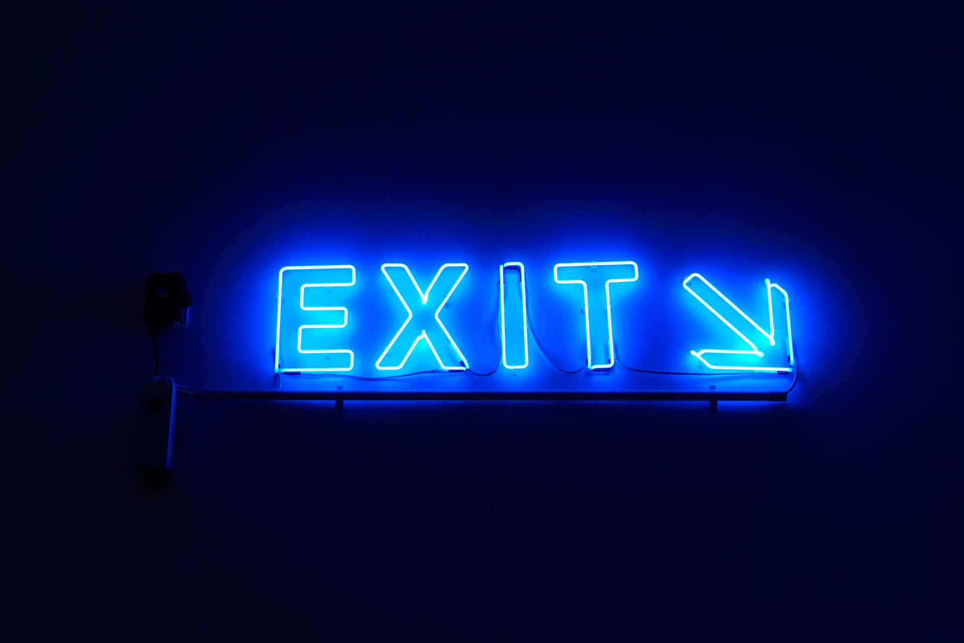 A Blue Neon Sign With The Word Exit Background