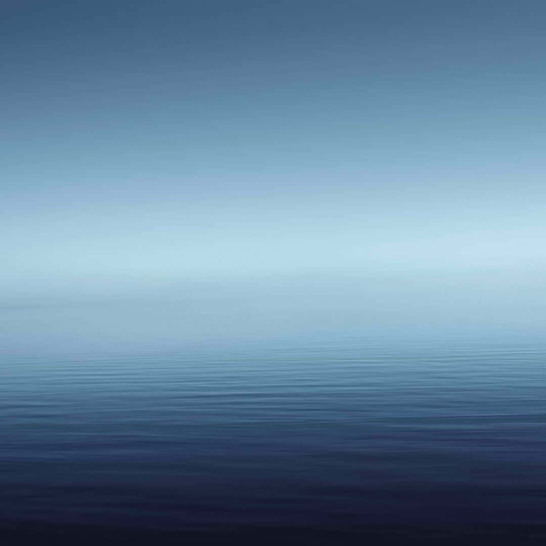 A Blue Sky With A Calm Ocean Background