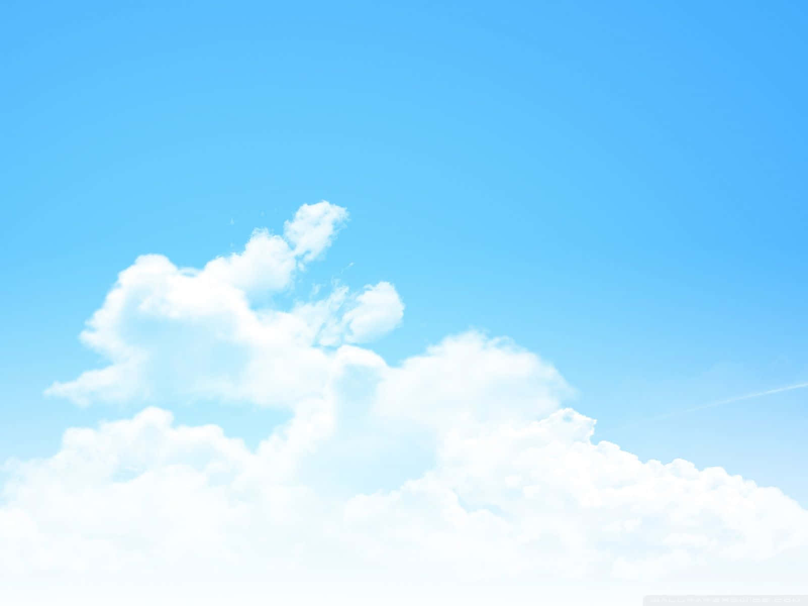 A Blue Sky With Clouds And A Plane Flying Over It Background