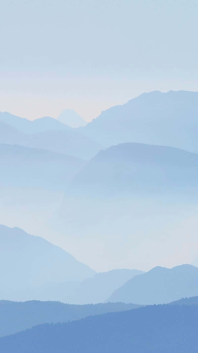 A Blue Sky With Mountains In The Background Background