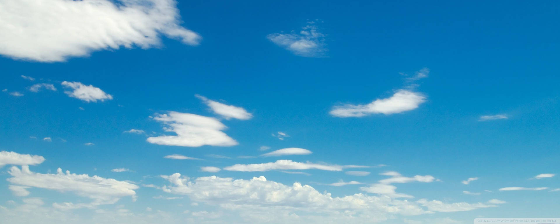 A Blue Sky With White Clouds And A Plane Flying Over It Background