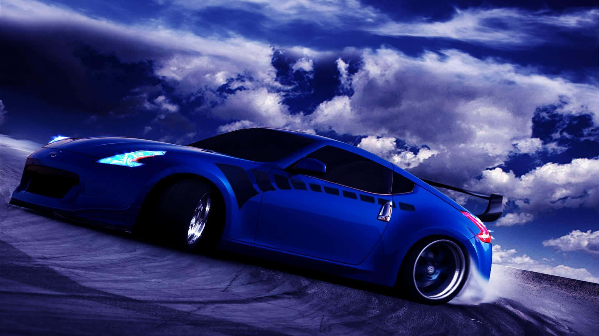 A Blue Sports Car Driving Down A Road With Clouds In The Background
