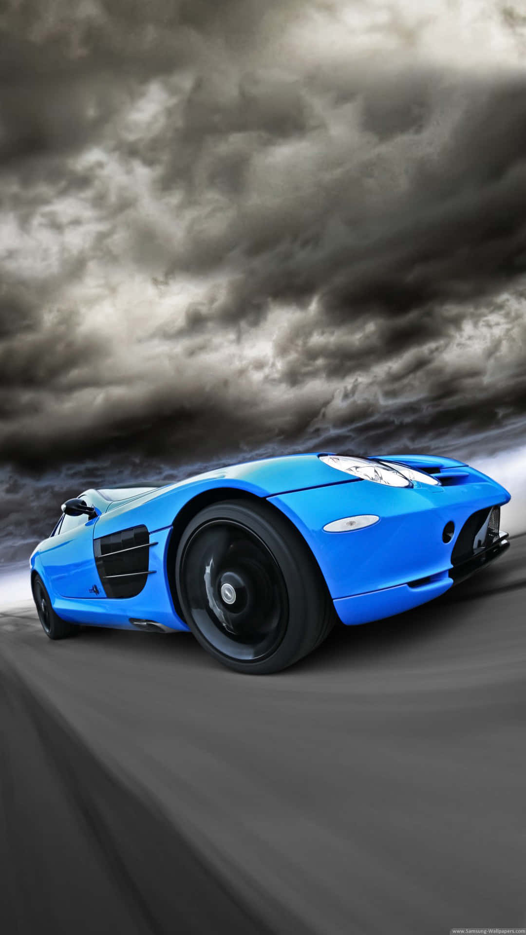 A Blue Sports Car Driving On A Road Background