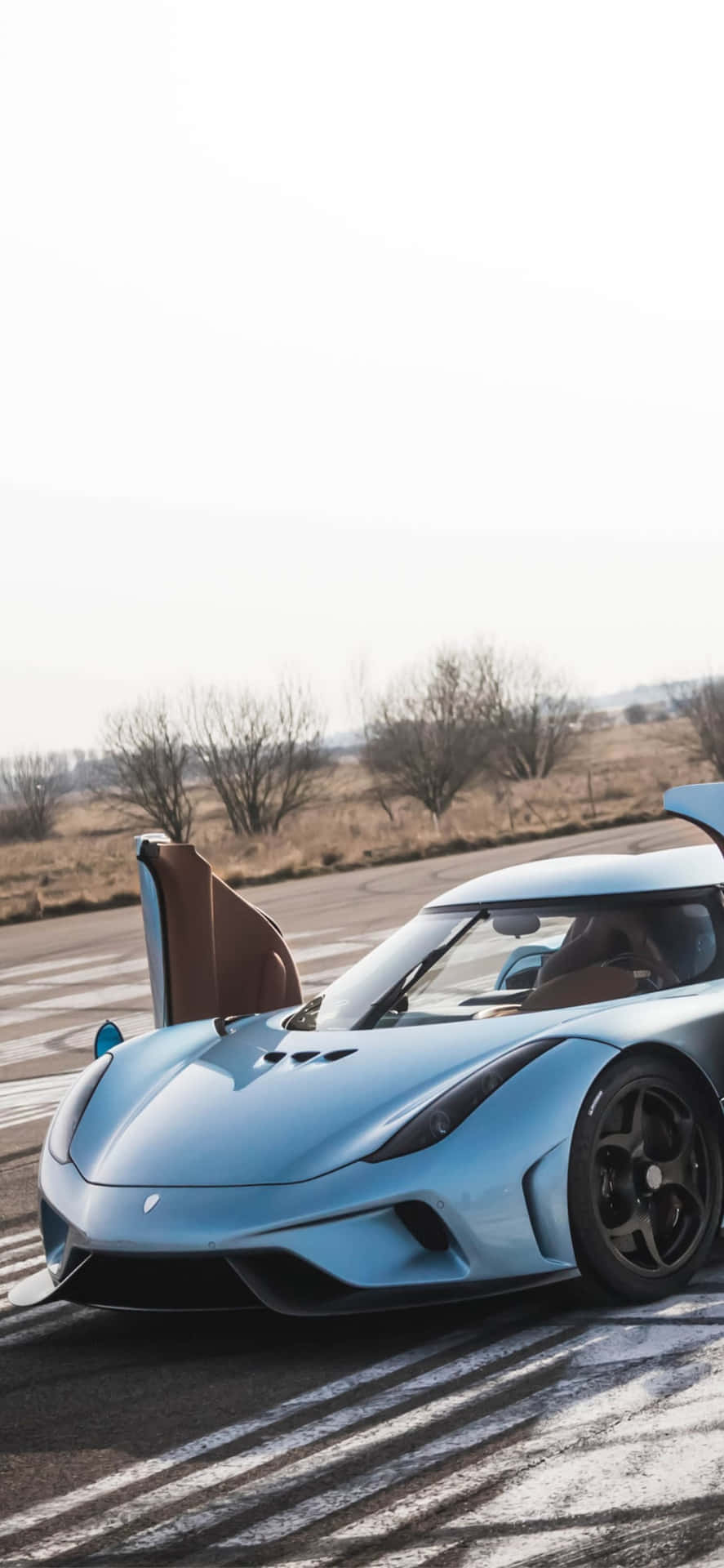 A Blue Sports Car Is Driving On The Road Background