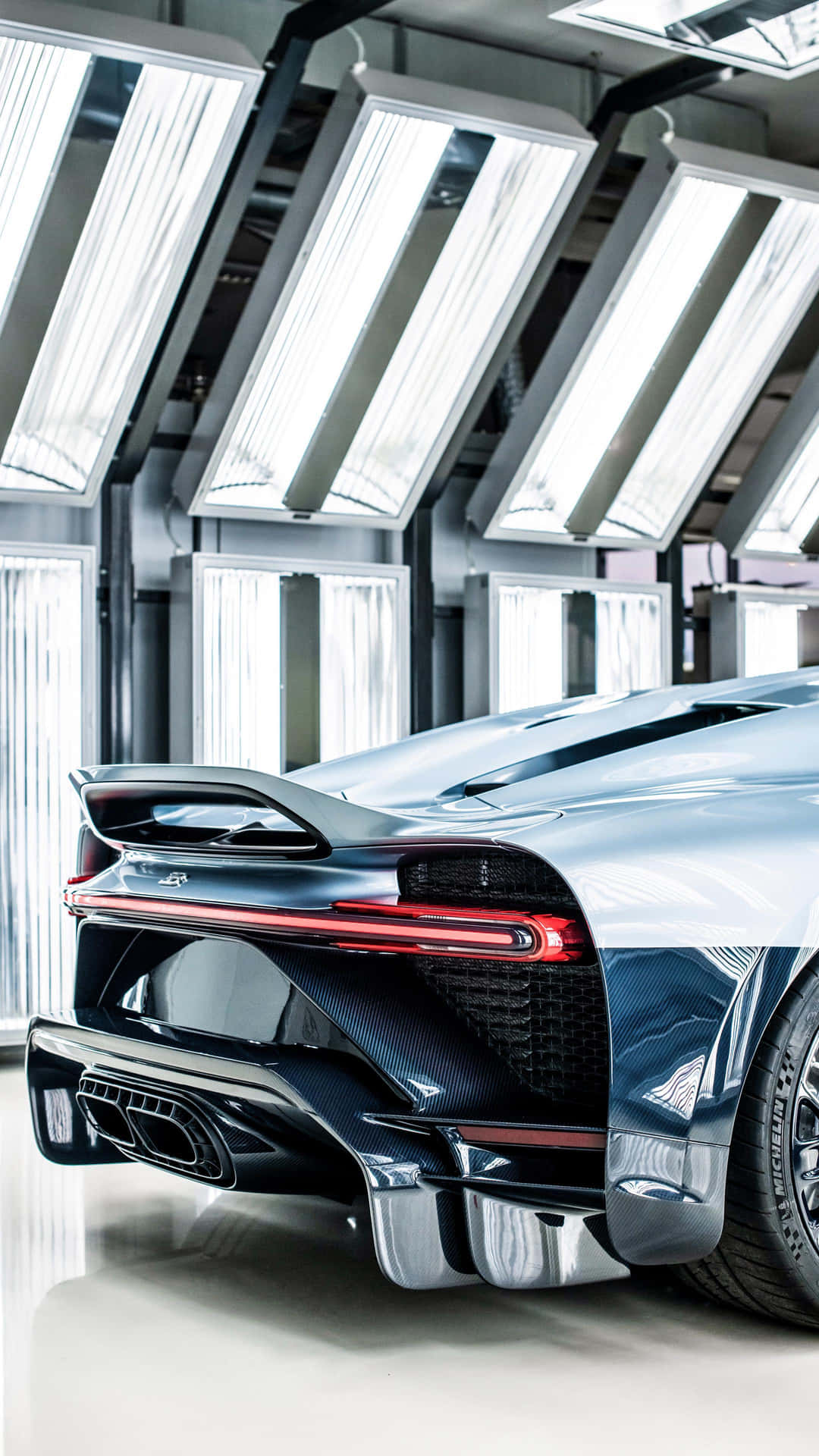 A Blue Sports Car Is Parked In A Garage Background