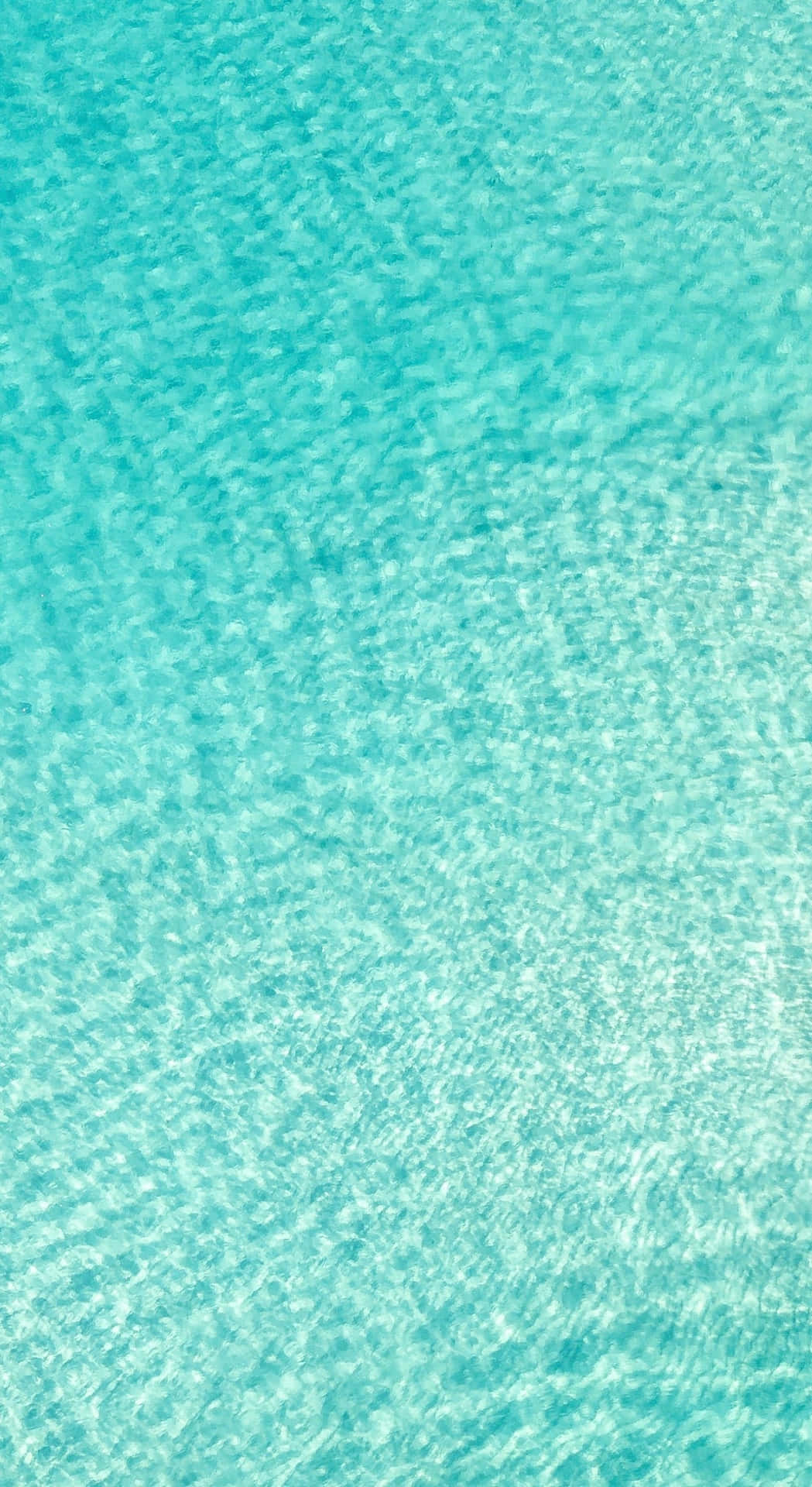 A Blue Water Surface With A White Sand Beach Background