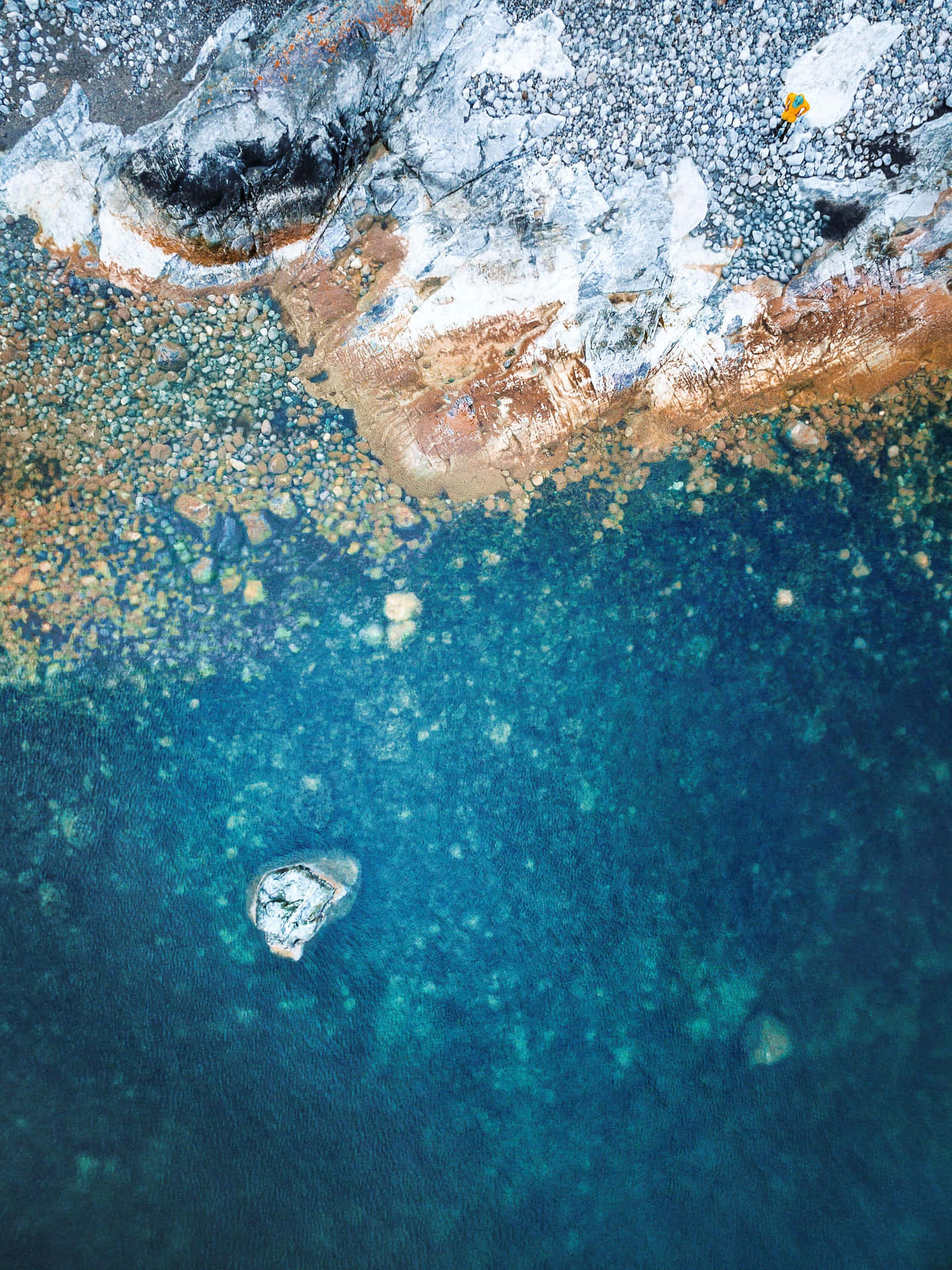 A Blue Water With A Rock In It Background