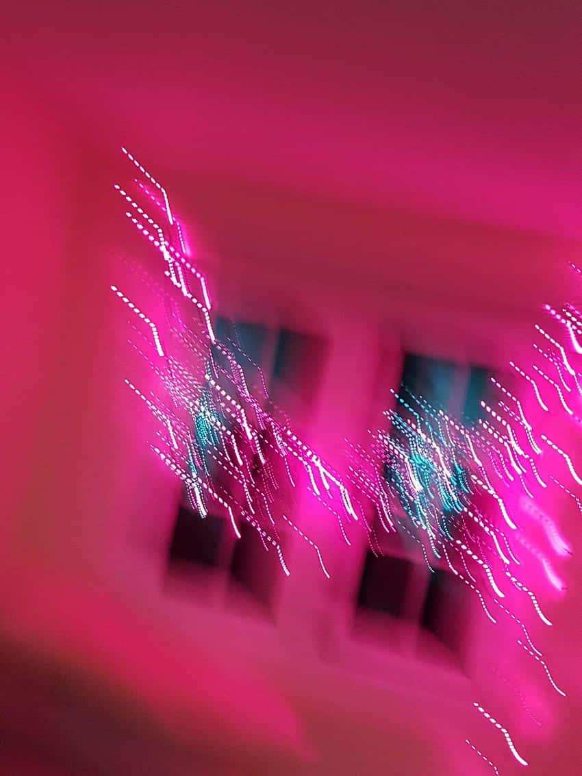 A Blurry Image Of A Pink Light In A Room Background