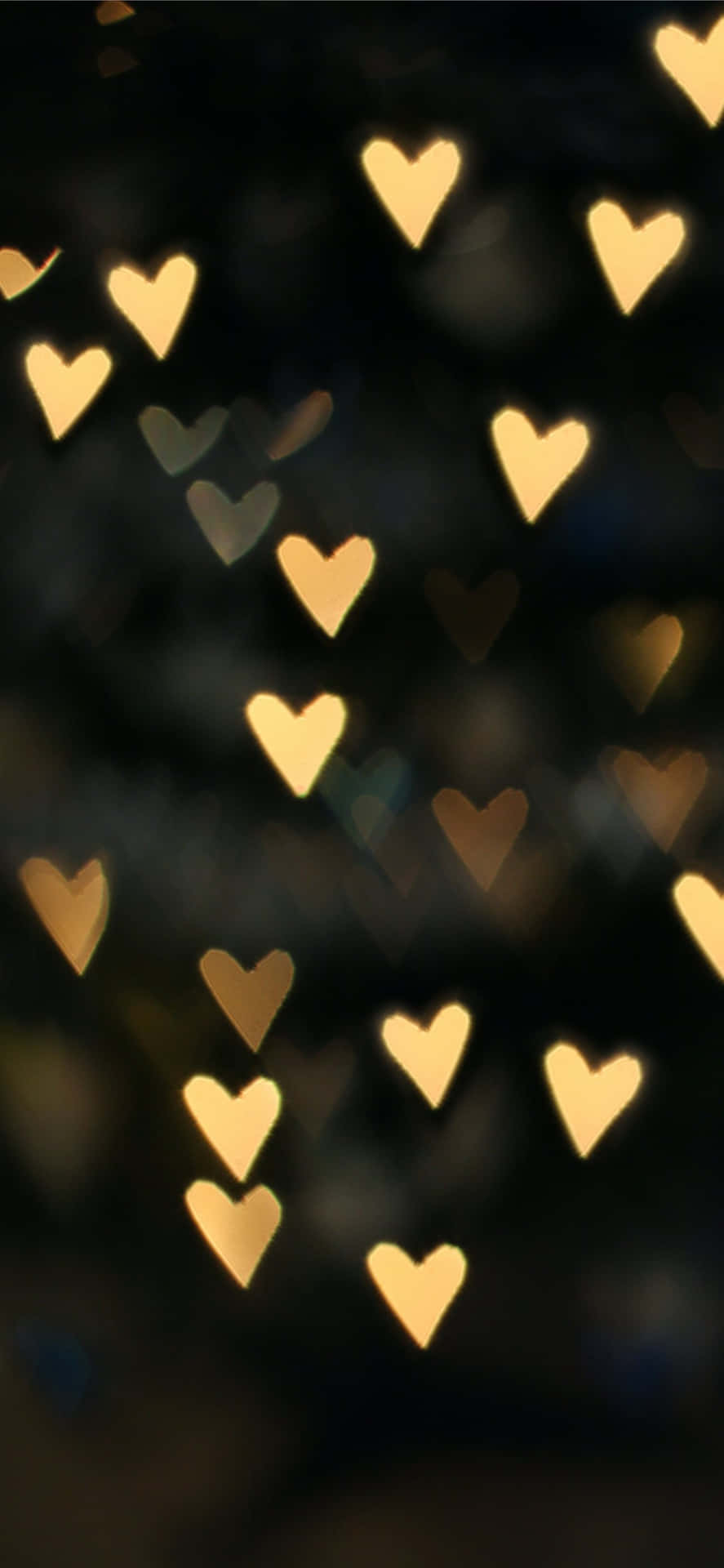 A Blurry Image Of Many Hearts In The Dark Background